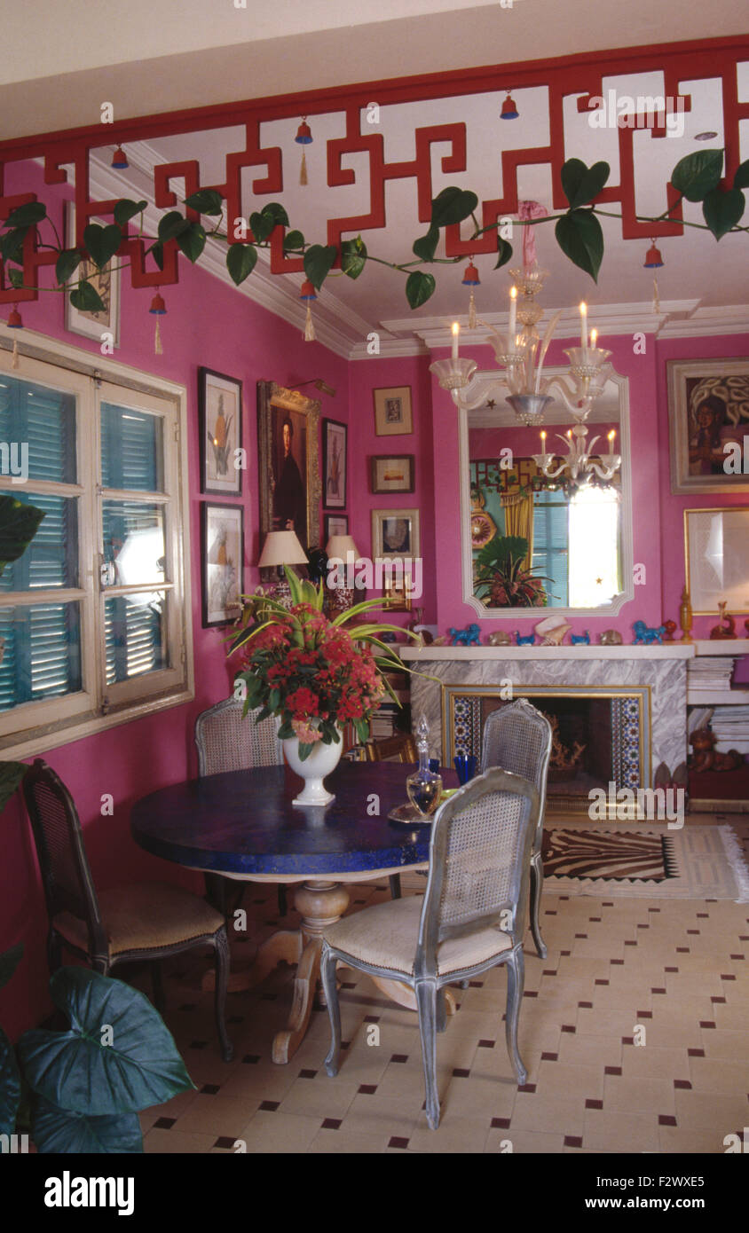 Mesa y sillas francesas pintadas de color rosa brillante comedor con  decoración calados en el techo Fotografía de stock - Alamy