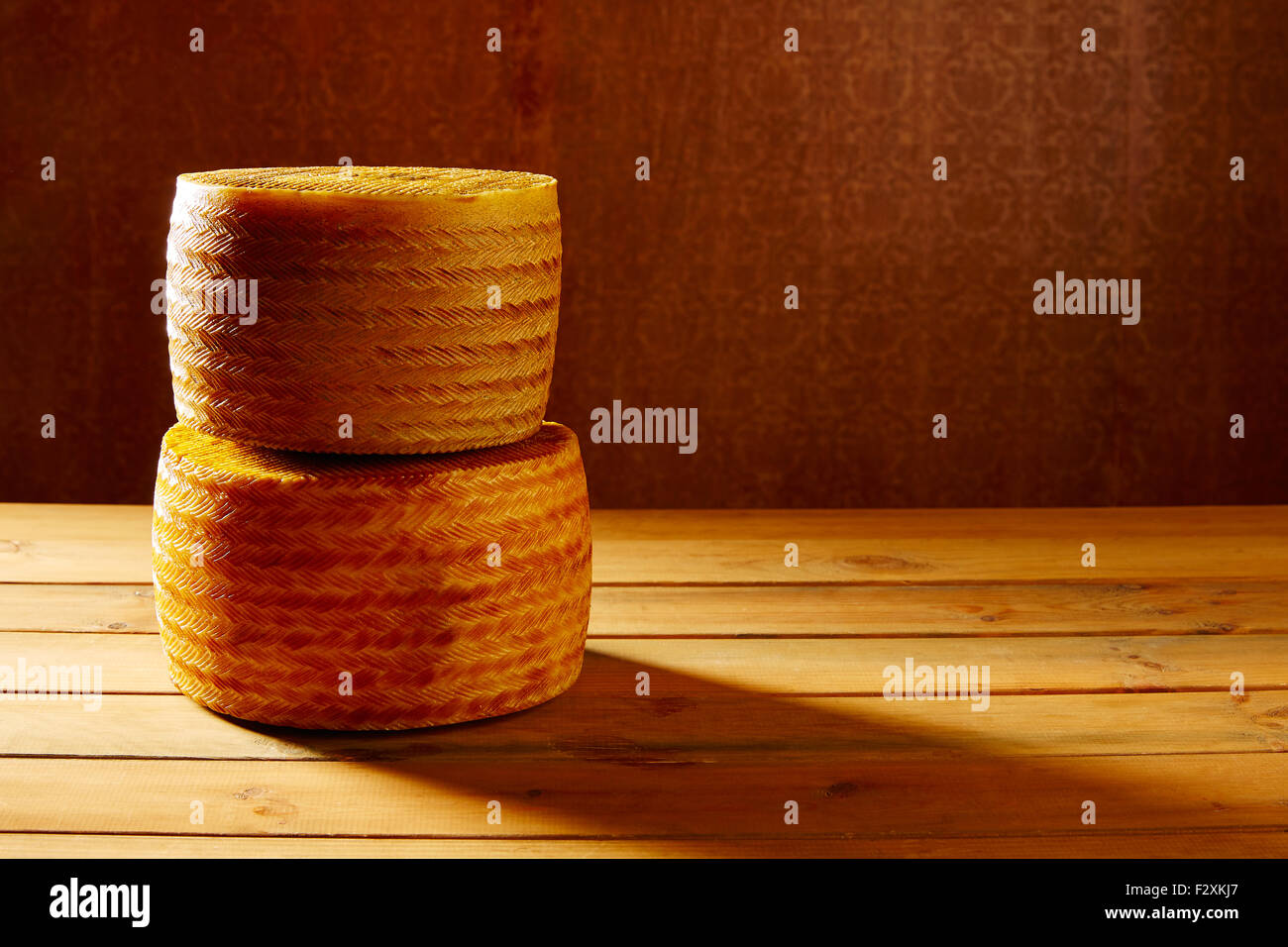 El queso manchego desde España en mesa de madera apiladas Foto de stock