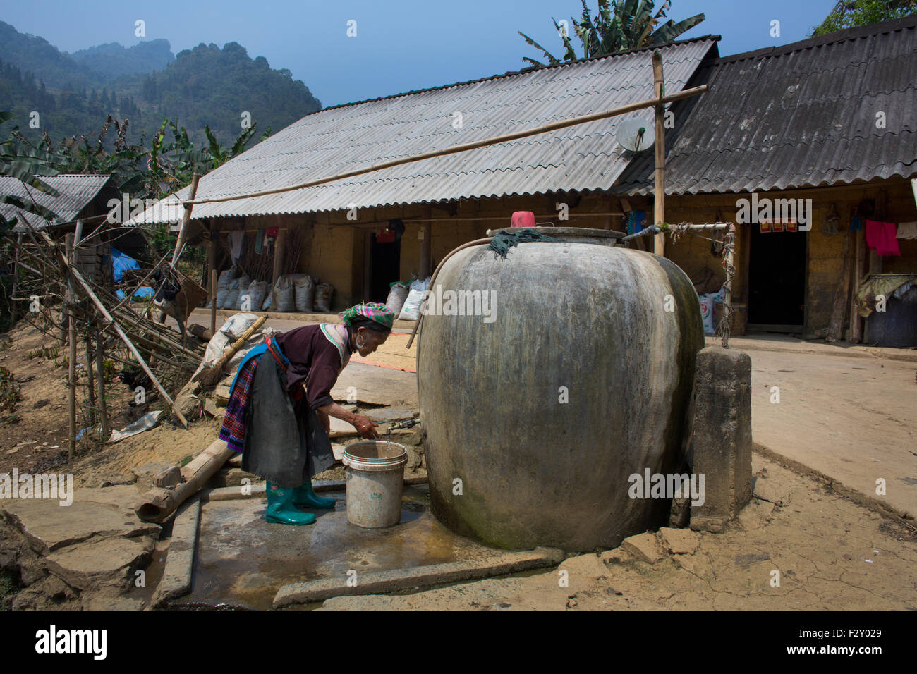 Los Hmong es el acarreo de agua desde un Barril de almacenamiento Foto de stock