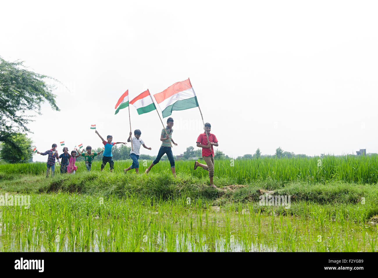 Grupo infantil rural indio multitudes granja ondeando la bandera el día de la Independencia Foto de stock