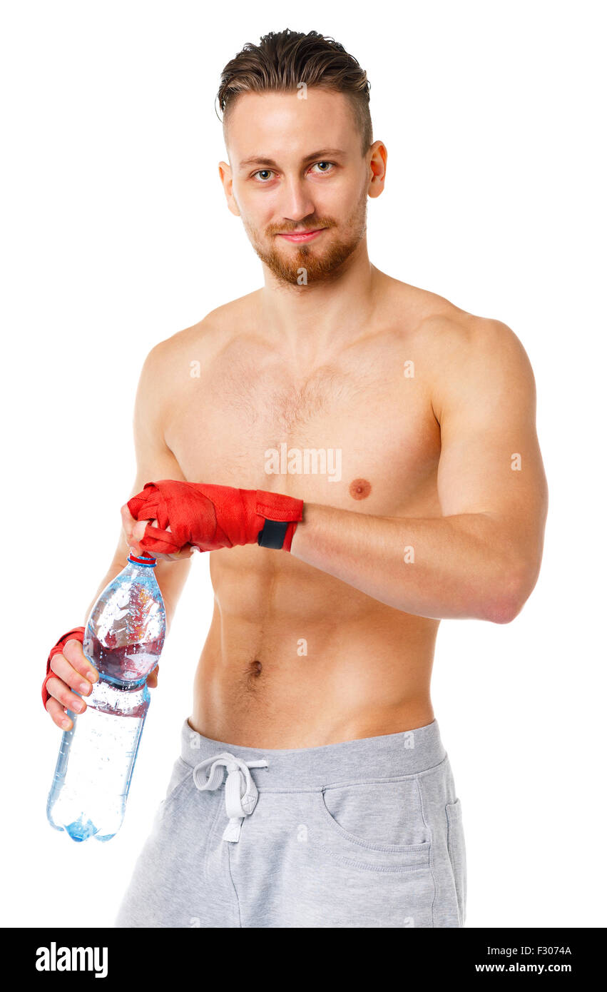 Deporte atractivo hombre vestido con vendas de boxeo y beber agua fresca en el fondo blanco. Foto de stock
