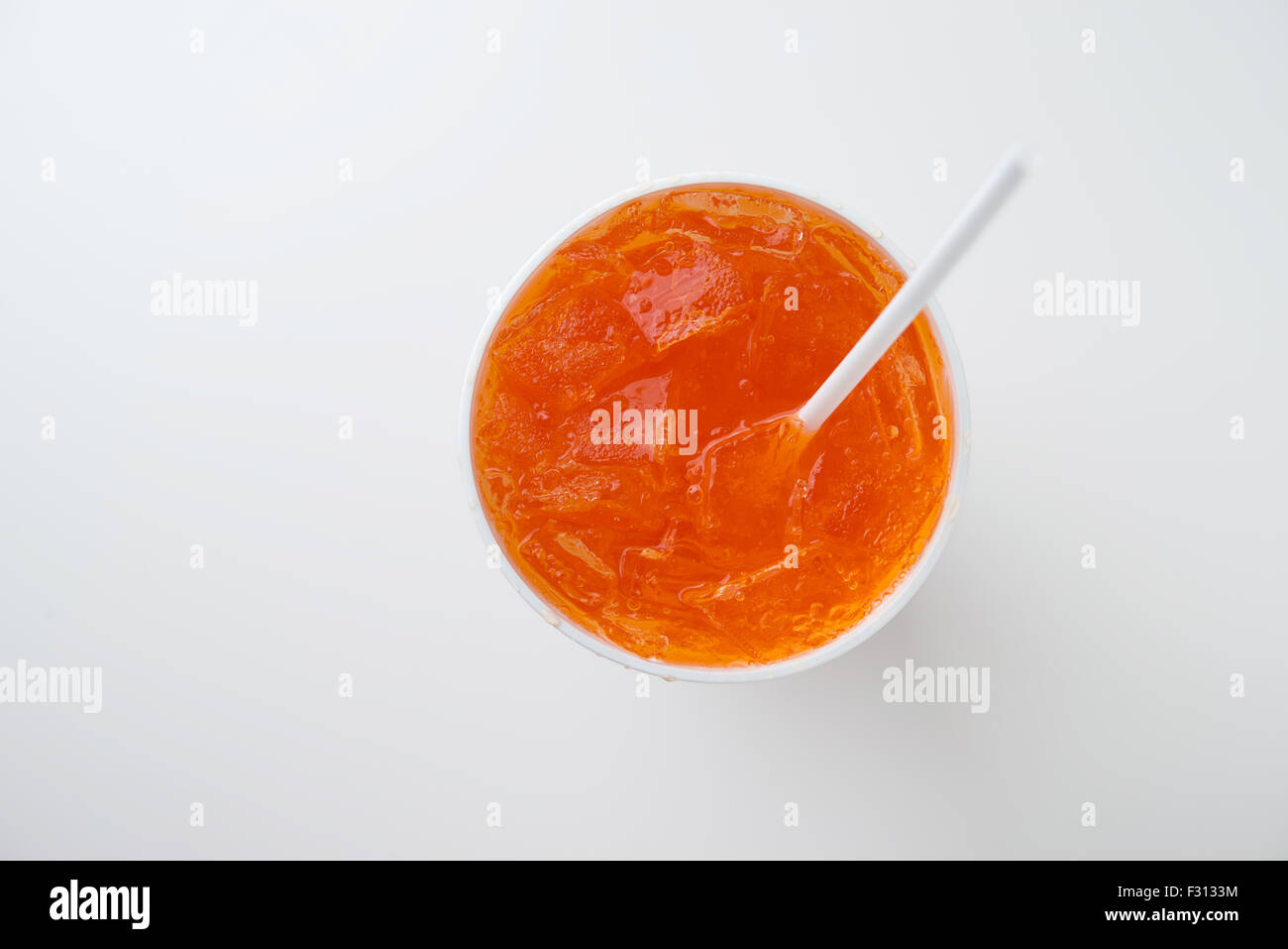 Refresco de naranja con paja para beber en vaso desechable Foto de stock