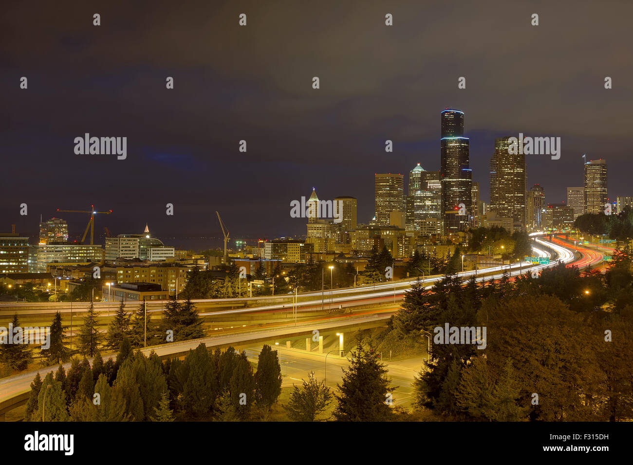 Seattle, Washington el centro de la ciudad con el tráfico de la autopista estelas de luz durante la noche hora azul Foto de stock