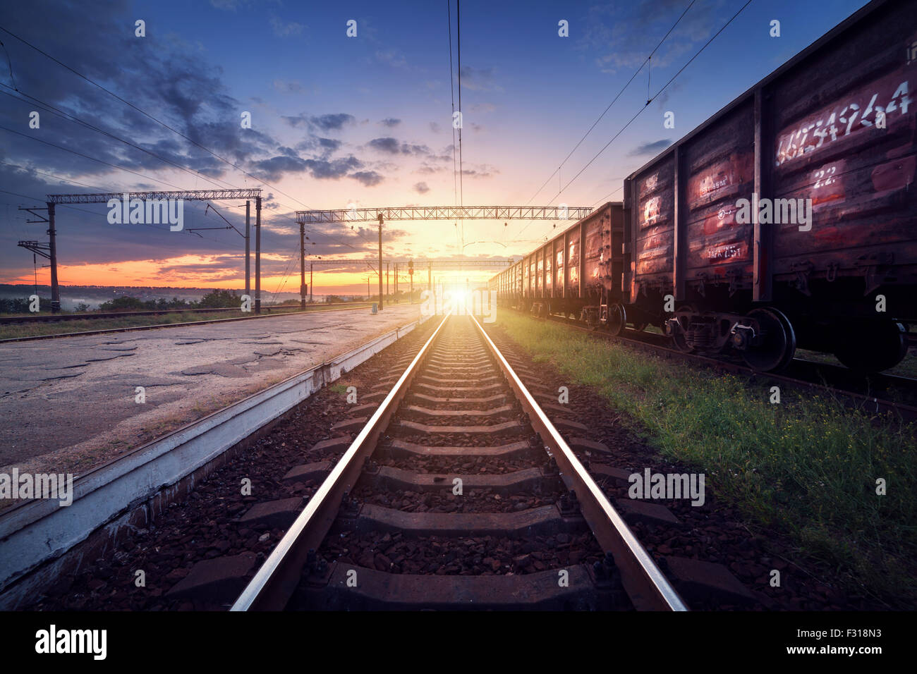 Plataforma de tren de carga por la noche. Ferrocarril en Ucrania. Estación de tren Foto de stock