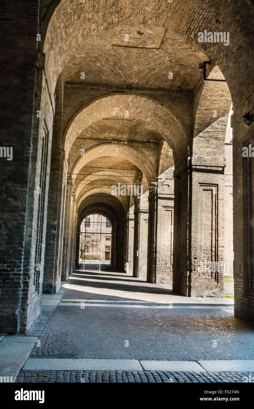 Arco, columnas, el patio y los adoquines en el Palacio de La Pilotta, Parma - Italia Foto de stock