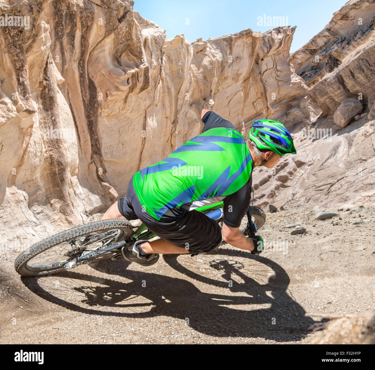 Ciclista de montaña cabalga una gravedad pendiente vía en un cañón. Foto de stock