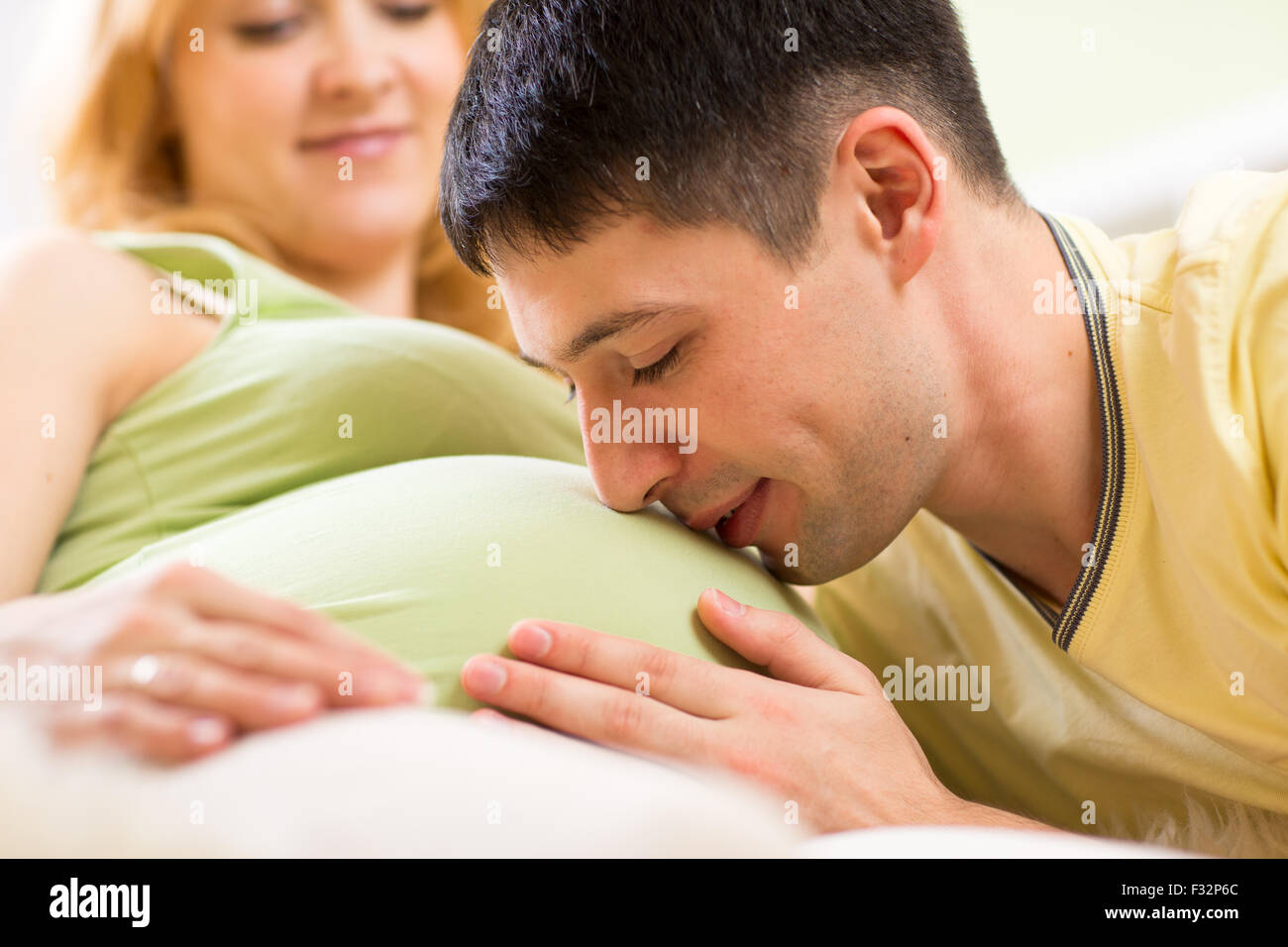 Futuro papá besando el vientre de su esposa embarazada Foto de stock