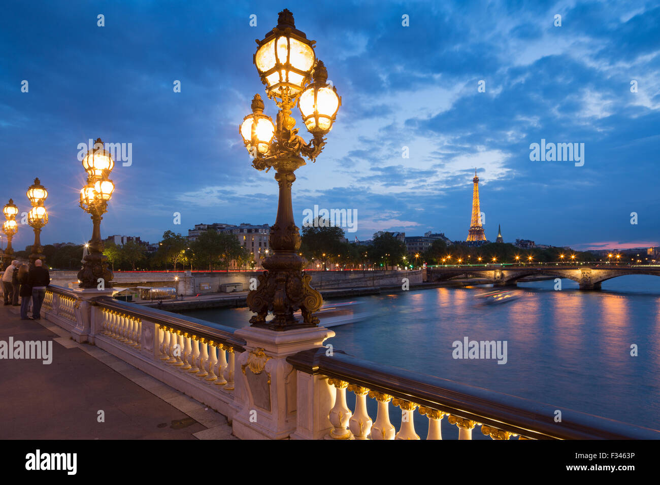 Pont Alexandre III, mirando hacia la Torre Eiffel sobre el Río Sena al anochecer, París, Francia Foto de stock