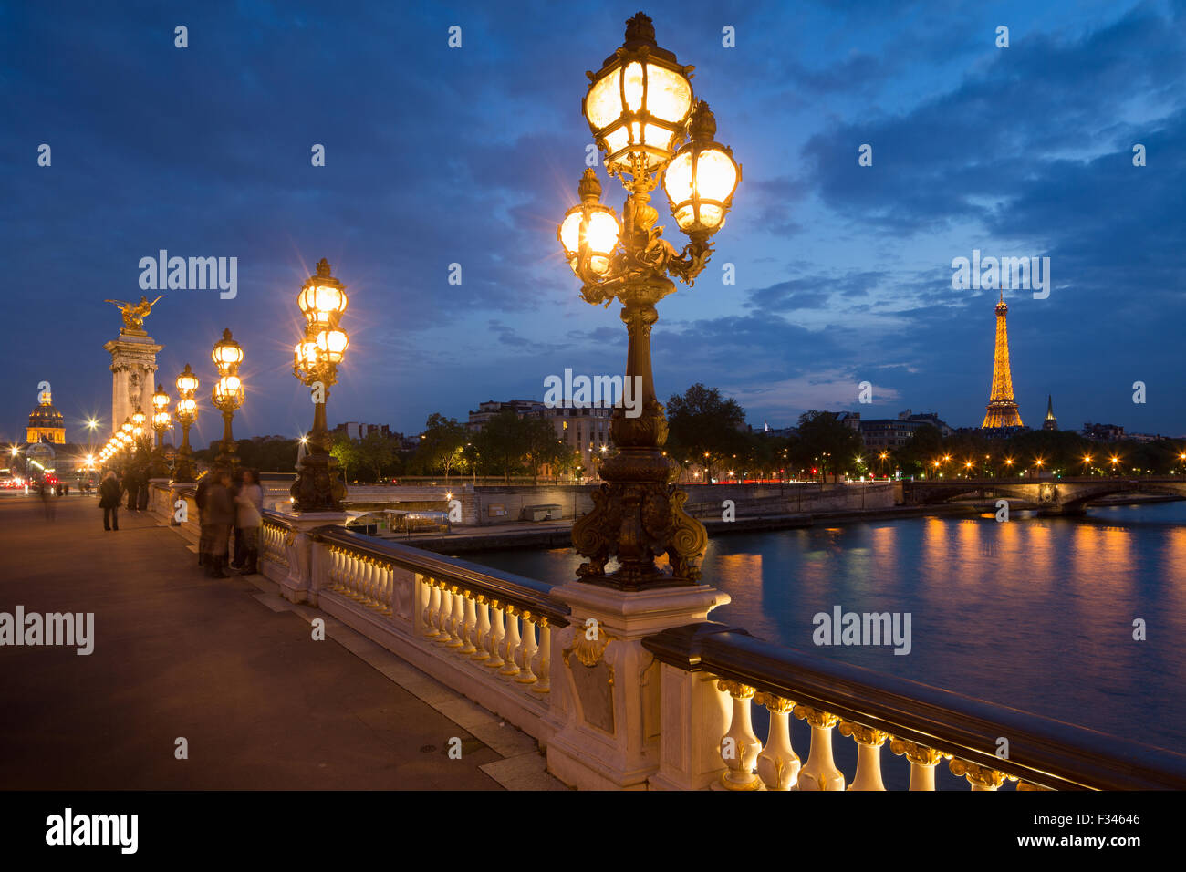 Pont Alexandre III, mirando hacia la Torre Eiffel sobre el Río Sena al anochecer, París, Francia Foto de stock