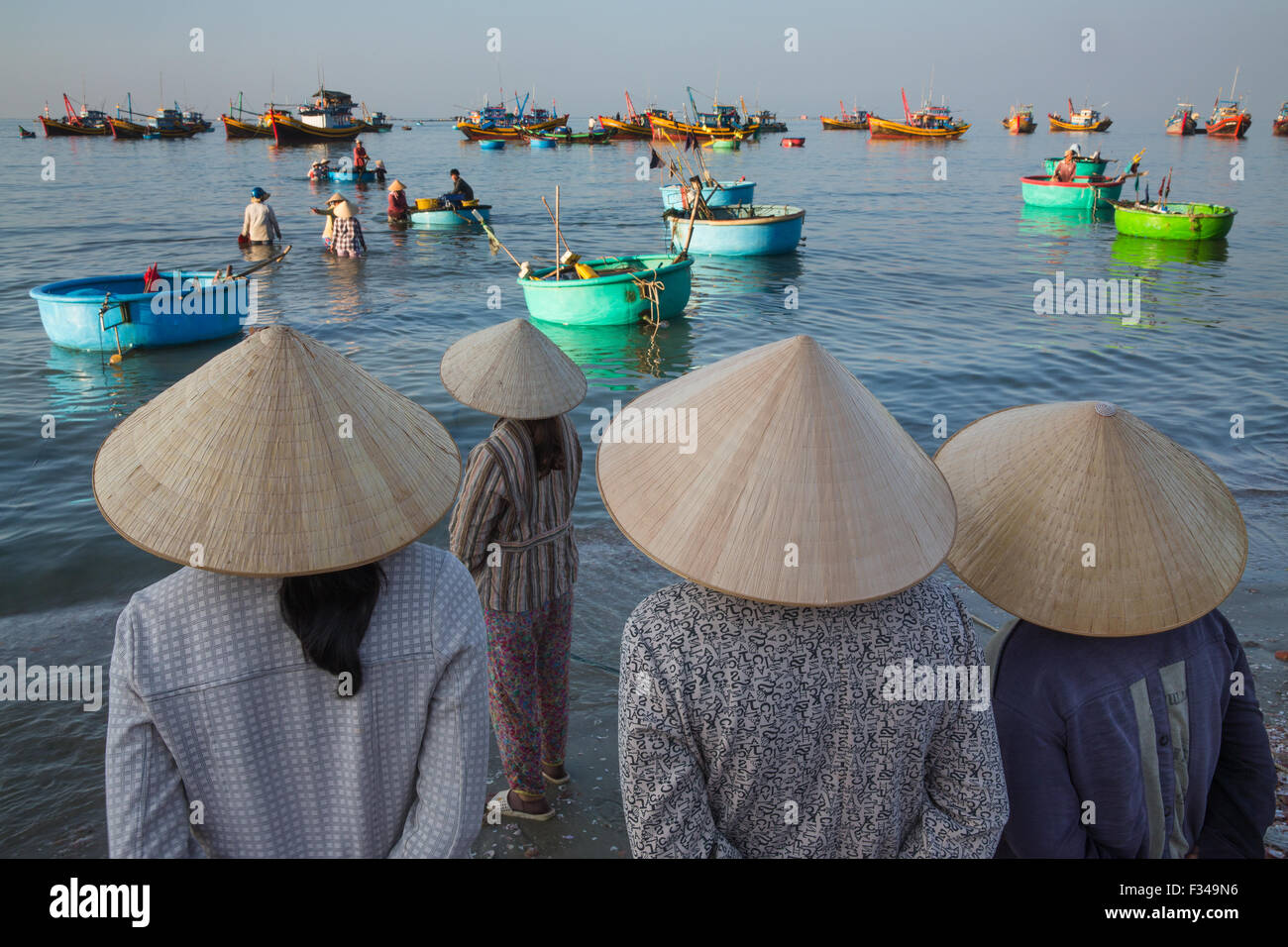 Señoras esperando el desembarque de la captura, el pueblo de pescadores de Mui Ne, Provincia Thuận Bình, Vietnam Foto de stock