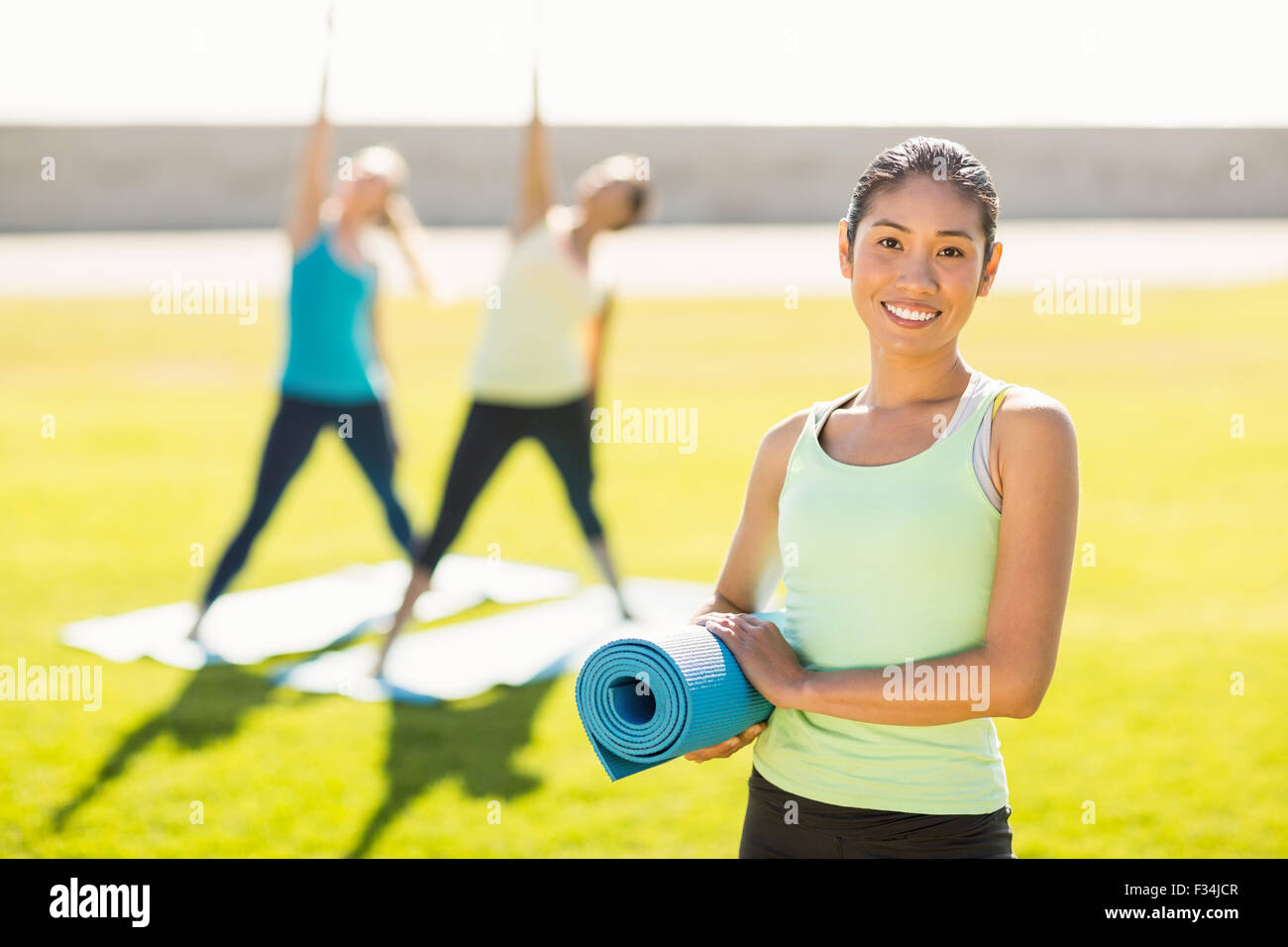 Sonriente mujer deportiva en frente de amigos haciendo ejercicios Foto de stock