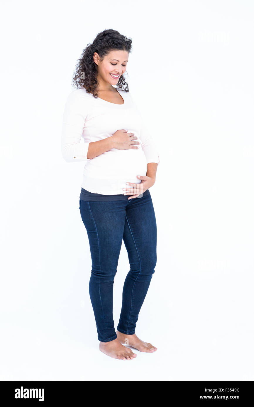 Mujer embarazada feliz celebración del abdomen Foto de stock