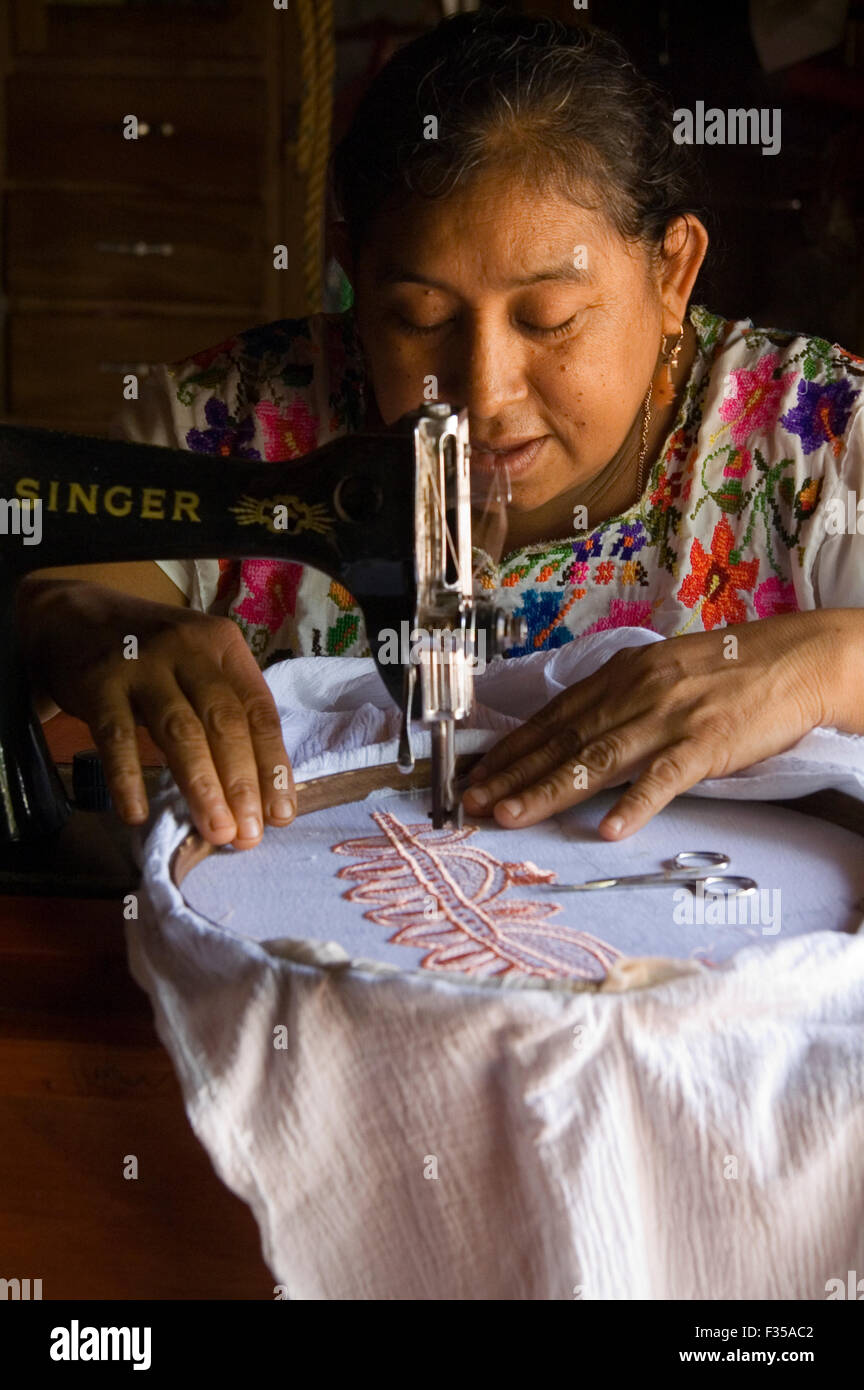 Mujer Maya con una antigua máquina de coser Singer a bordar una falda en su  casa Fotografía de stock - Alamy
