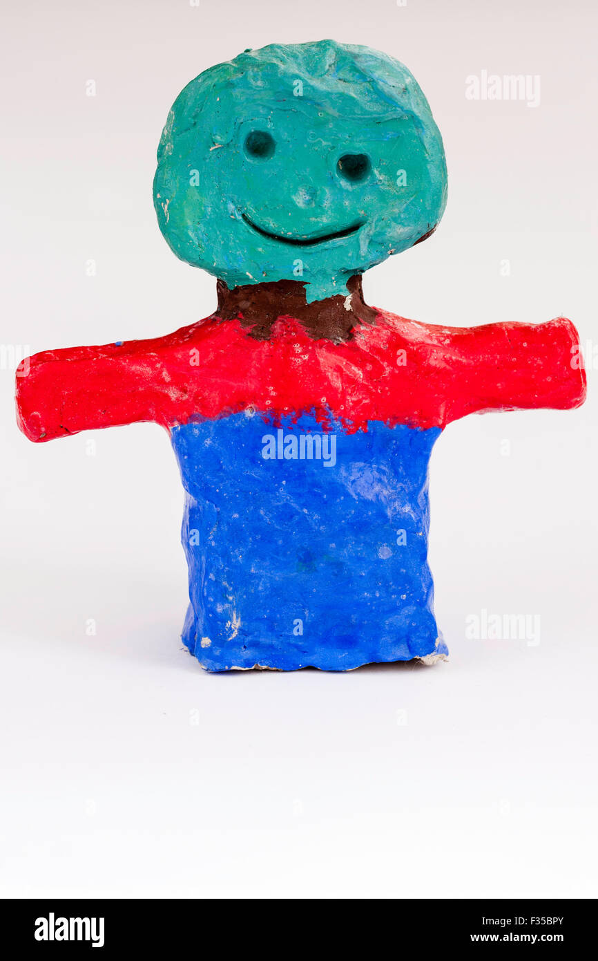 Niño hechas de plastilina, modelo de arcilla de un hombre sonriente, feliz con los brazos extendidos. Torse Greenhead, rojo y brazos y base azul. Foto de stock
