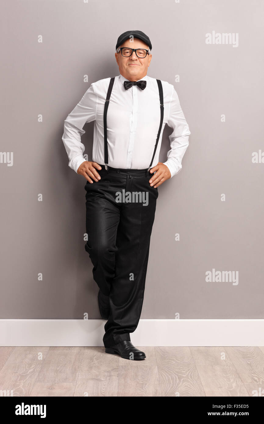 Retrato de una longitud completa de moda caballero senior negro tirantes y pajarita una pared Fotografía de stock - Alamy