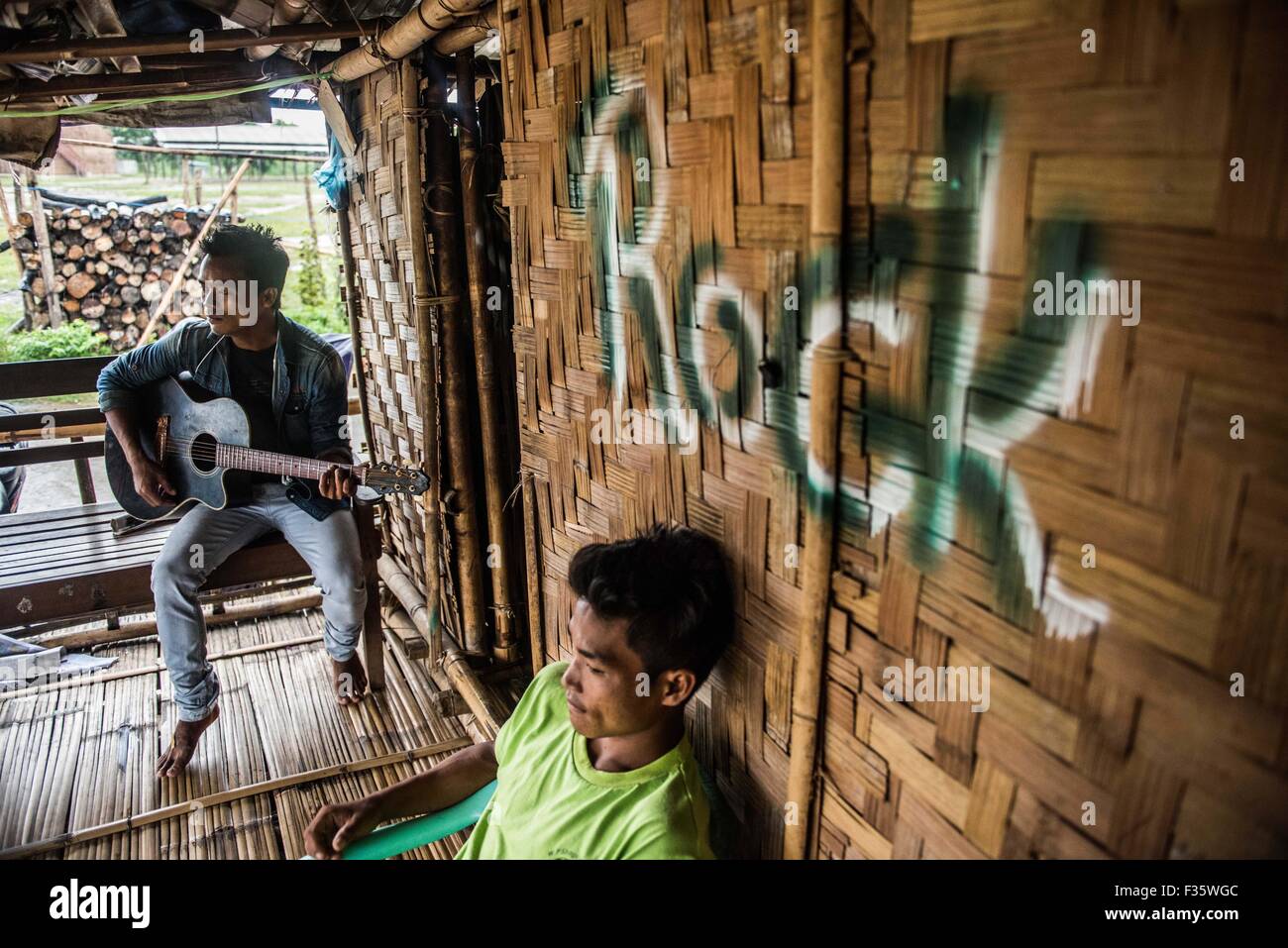 Un refugiado de kachin toca la guitarra en un campamento de refugiados en el estado de Kachin, en Myanmar Foto de stock
