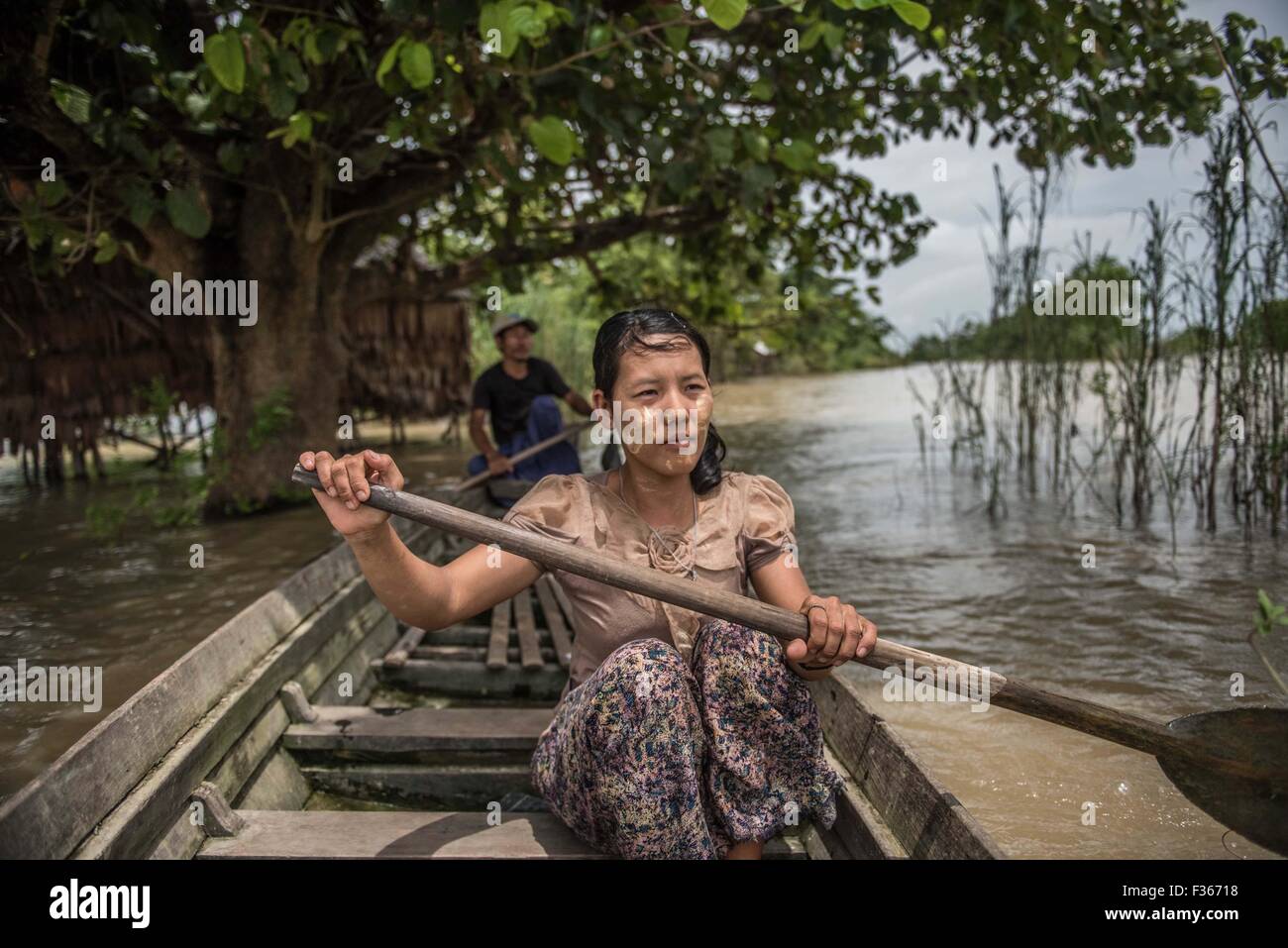 Una mujer remos a través de zancudos en aldeas inundadas del delta de Irrawaddy, en Myanmar. Foto de stock