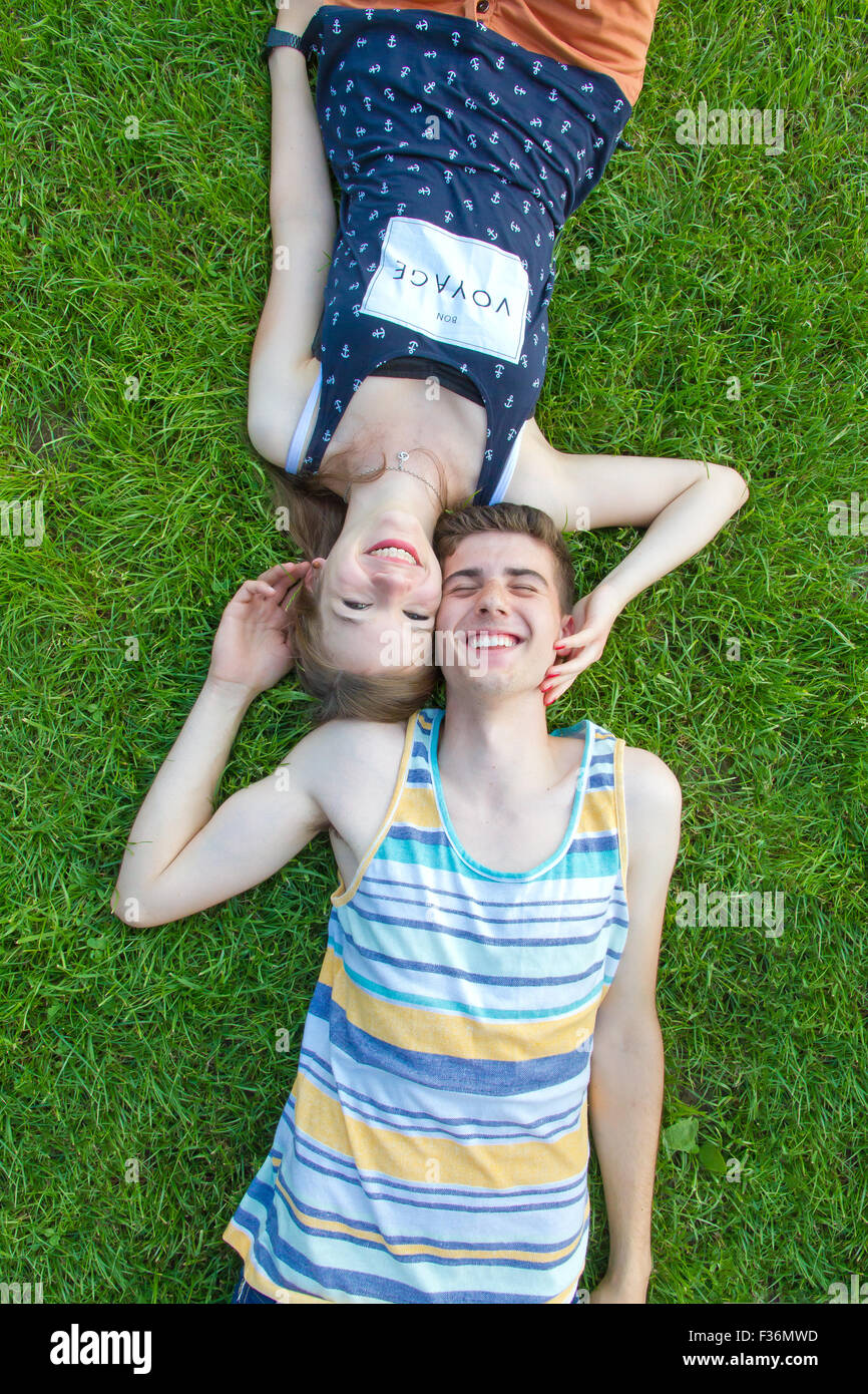 Feliz pareja joven tumbado en la hierba Foto de stock