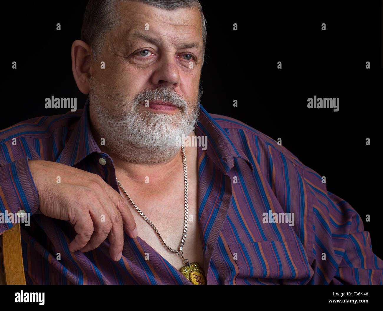 Buen retrato de un hombre senior reflexiva en camisa a rayas Foto de stock