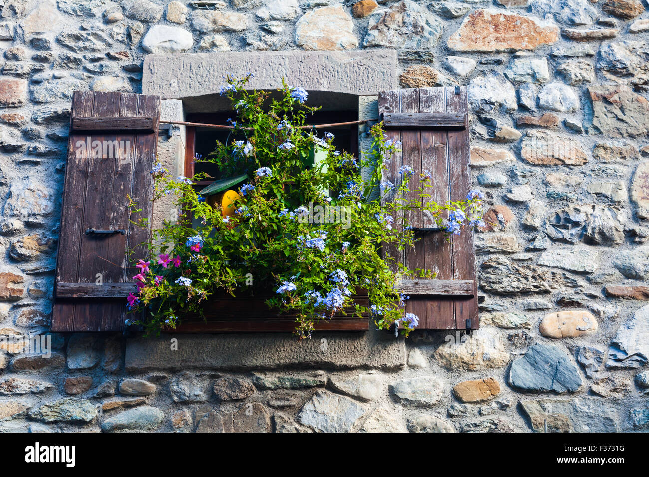 Ventanas con persianas y flores por encima de las estrechas calles de punta  de Yvoire, Haute Savoie, Francia Fotografía de stock - Alamy