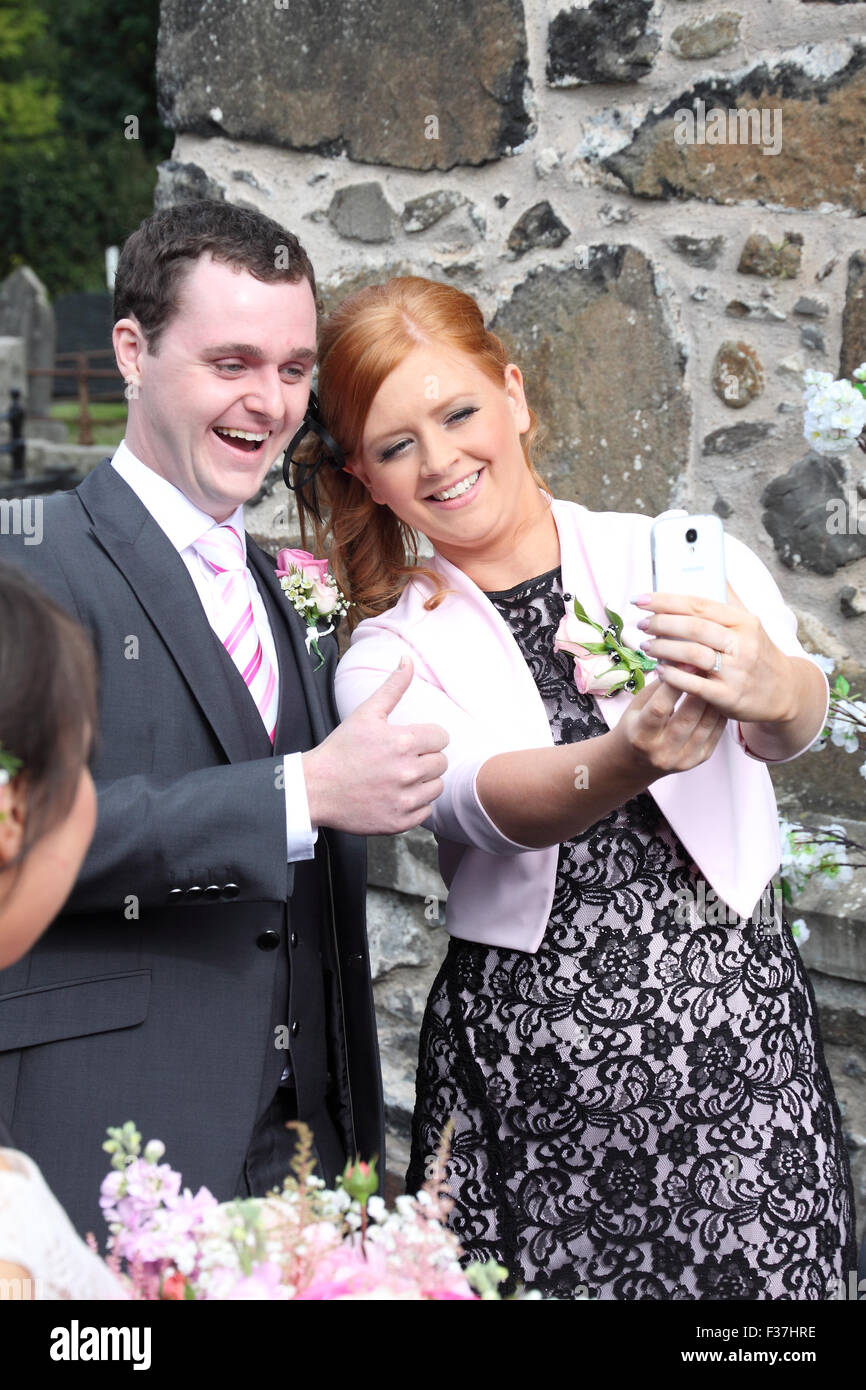 Los invitados a la boda teniendo un selfie en un smartphone, REINO UNIDO Foto de stock