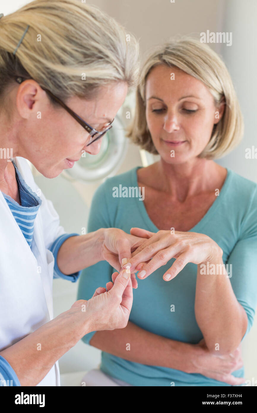 Dedos y uñas examen de un paciente. Foto de stock