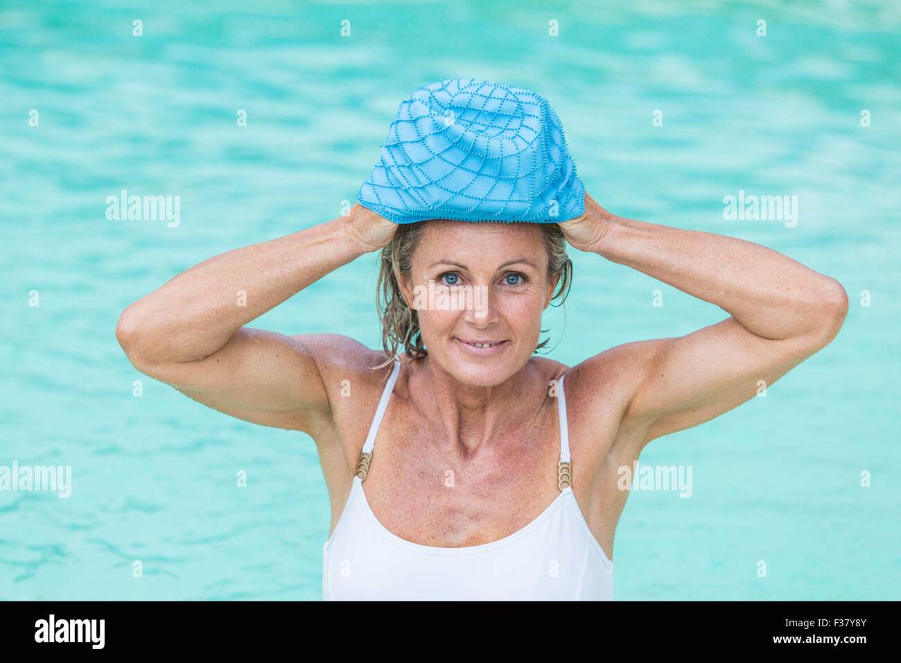 Una mujer en una piscina llevando un gorro de baño. Foto de stock