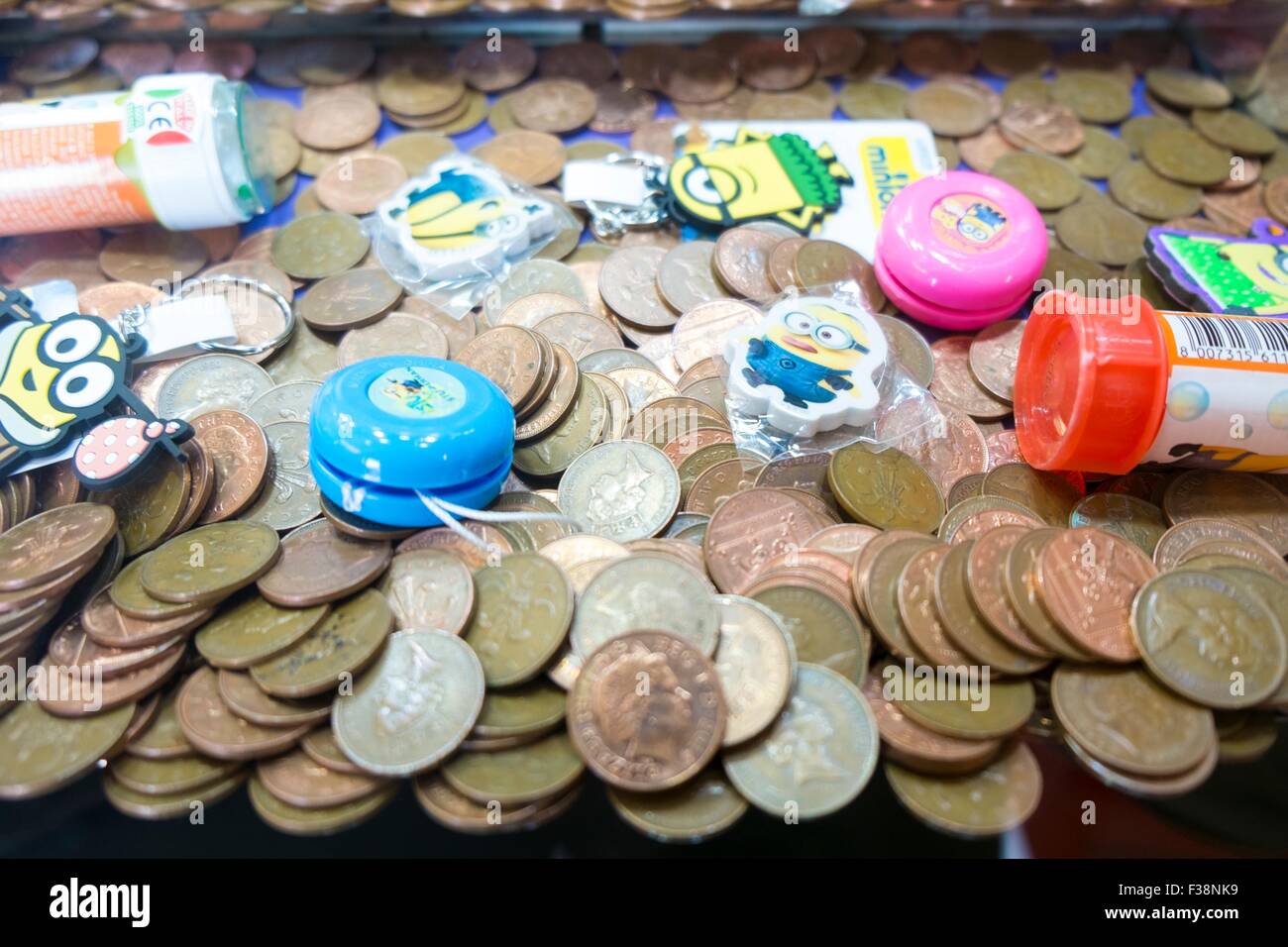 Las monedas de un centavo de caída de la máquina arcade. Foto de stock