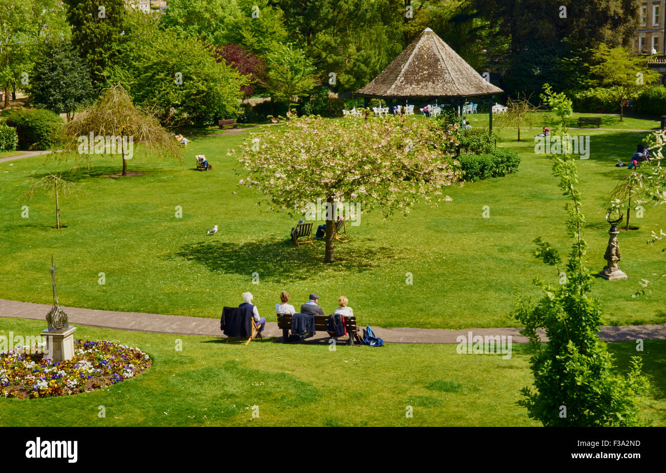 Vista aérea de césped y árboles en el jardín público, personas sentadas en los banquillos Foto de stock