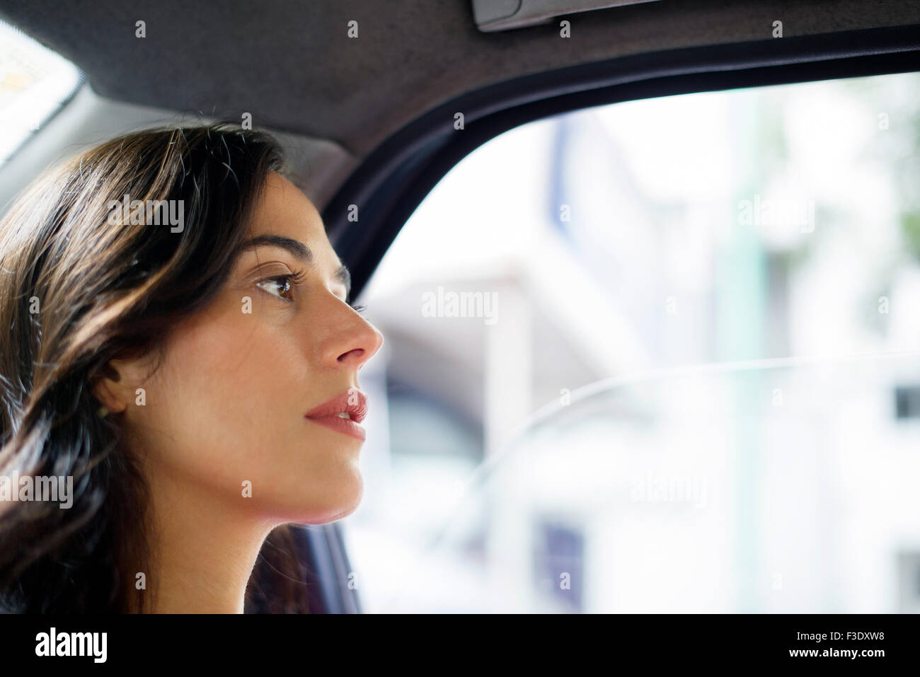 Mujer caballo en la parte trasera del coche, mirar lejos en el pensamiento Foto de stock