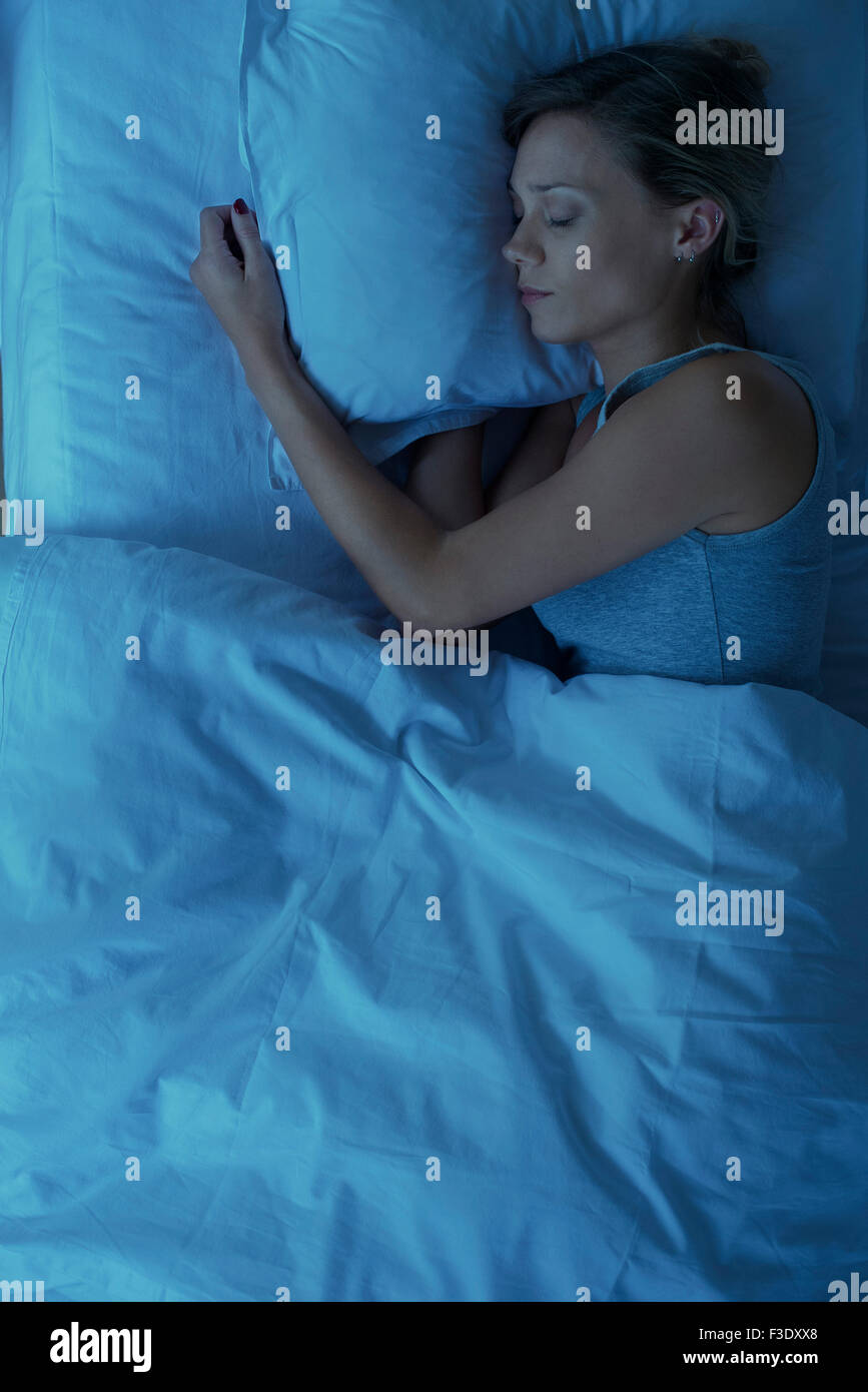 Mujer que duerme en la cama, vista superior Foto de stock