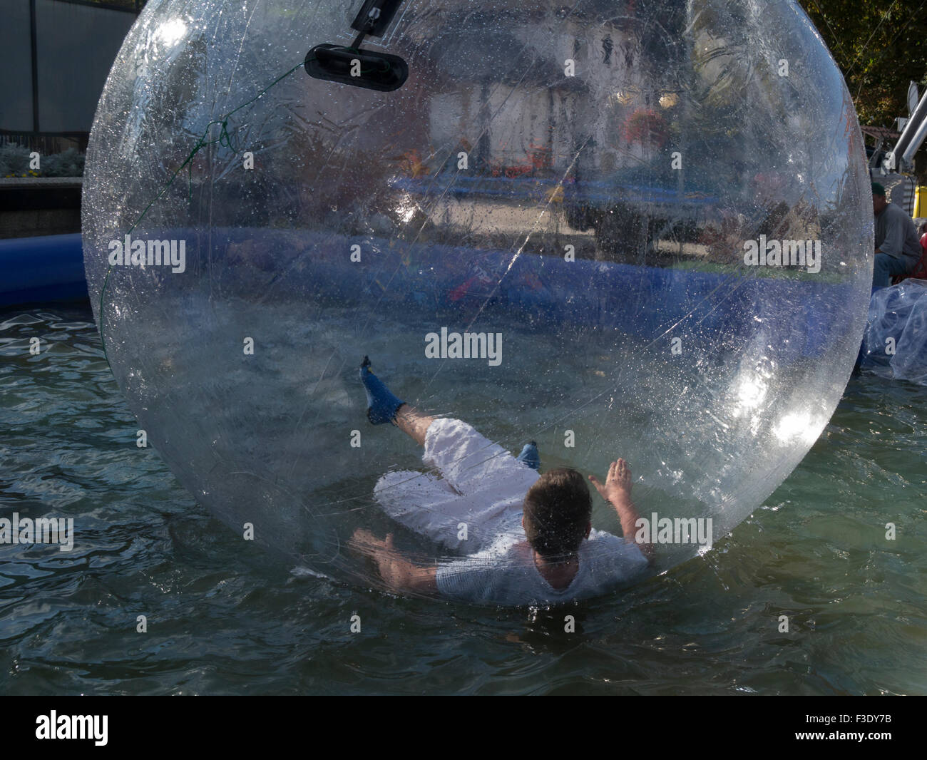 Joven agua caminar y rodar en agua inflables burbuja Polonia en piscina de bolas Foto de stock