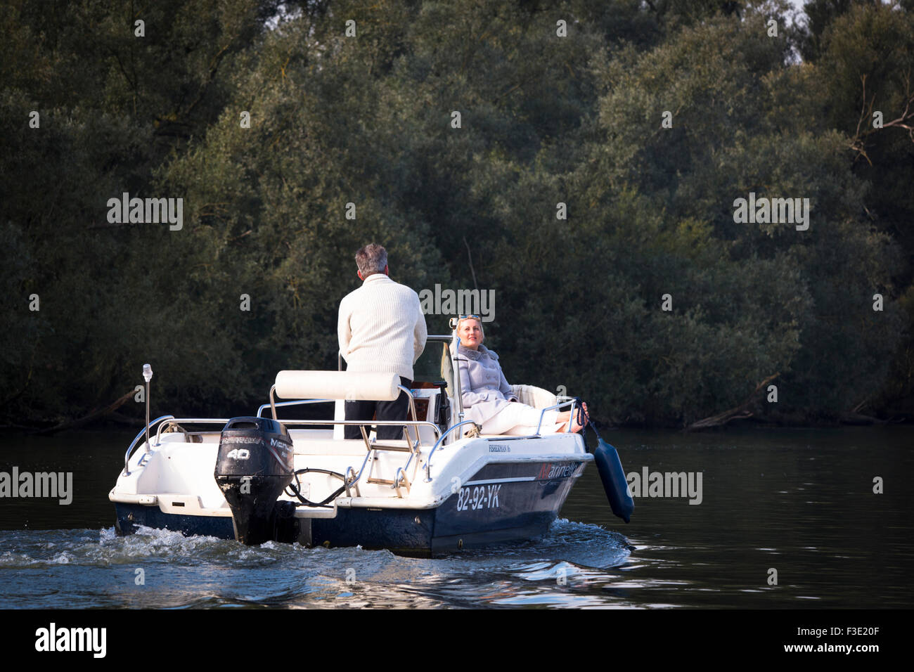 Pareja de mediana edad navegando en un barco en el parque nacional "el Biesbosch" en los Países Bajos Foto de stock