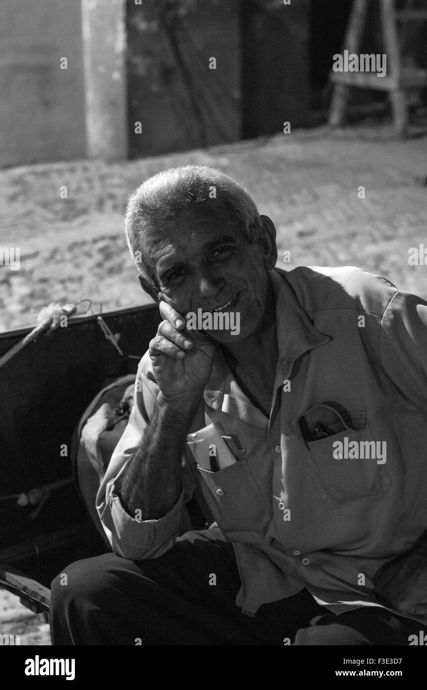 Retrato en blanco y negro de un hombre bien vestido local está sonriendo en la calle en Trinidad, una ciudad en el centro de Cuba. Foto de stock