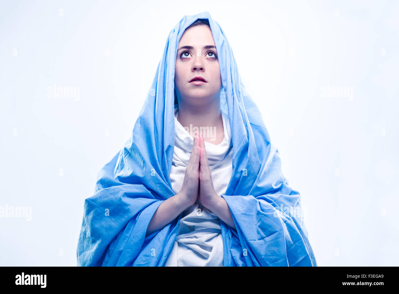 Virgen María rezando con velo azul sobre fondo blanco Fotografía de stock -  Alamy