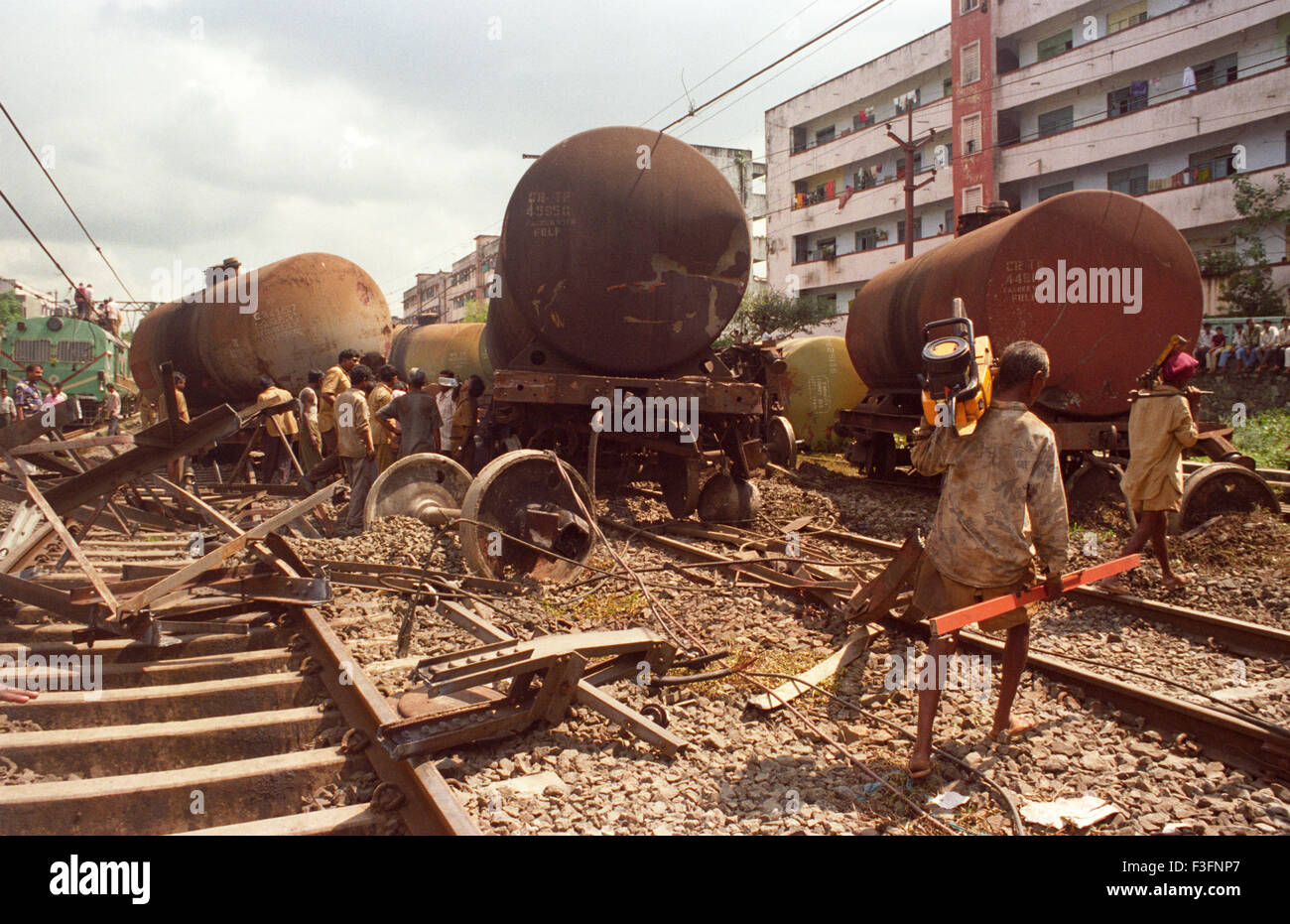 Los trabajadores ferroviarios mover un vagón de un tren de mercancías de grúa descarrilamiento Mulund estación en Bombay Bombay Foto de stock