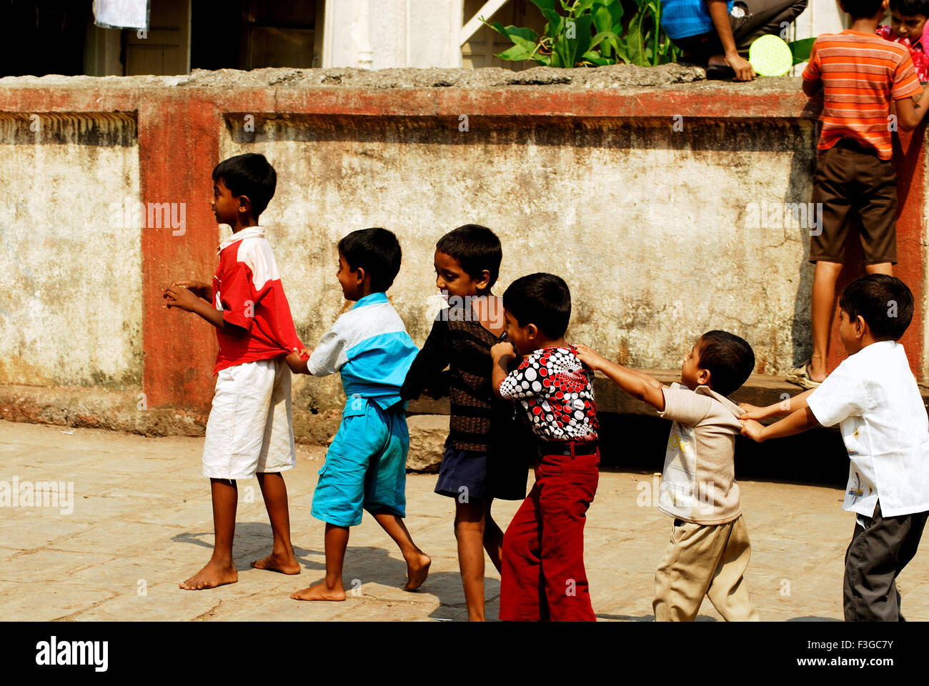 Niños jugando a "seguir al líder" en el tiempo libre Foto de stock