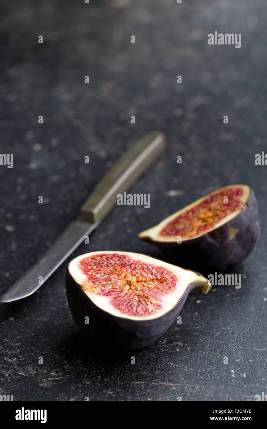 Higos frescos cortados en rebanadas sobre la mesa de la cocina Foto de stock