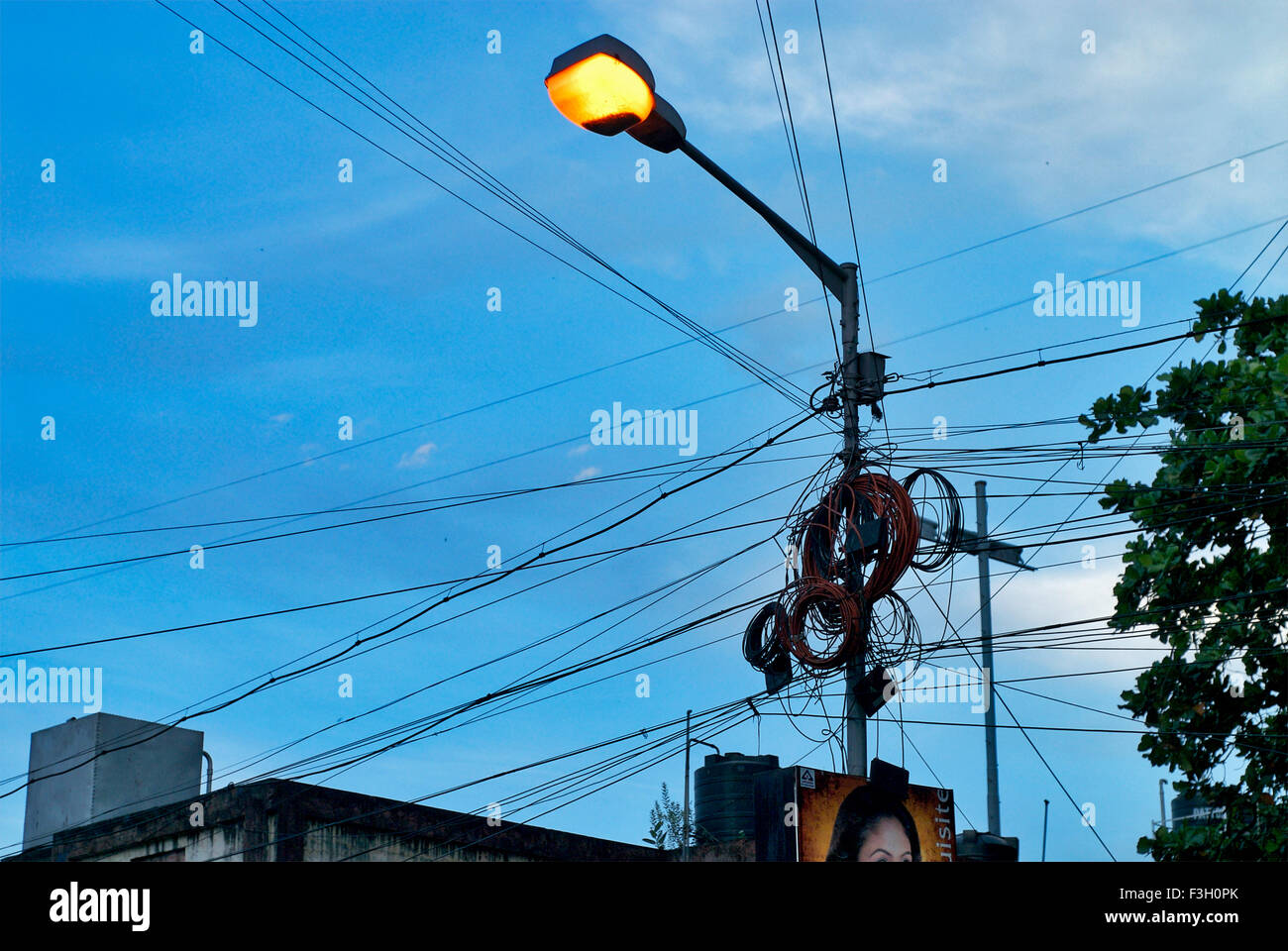 Cluster de hilos atados a la brillante luz de la calle post Calcuta ; ; ; La India Bengala occidental Foto de stock