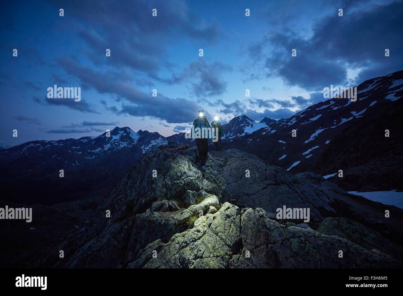 Pareja joven senderismo por la noche vestidos de faros, Val Senales Glaciar, Val Senales, Tirol del Sur, Italia Foto de stock