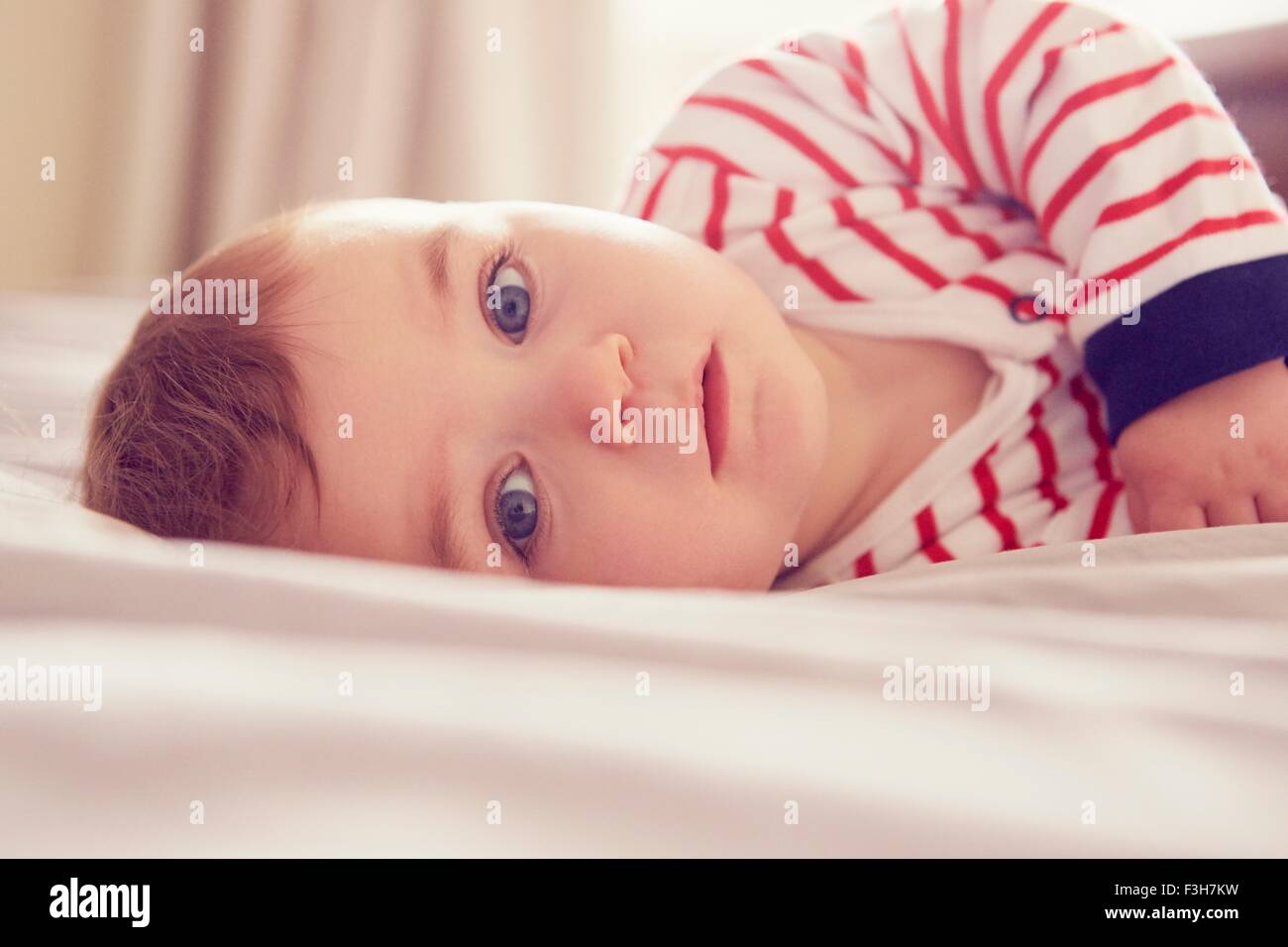 Baby Boy tumbado en la cama Foto de stock