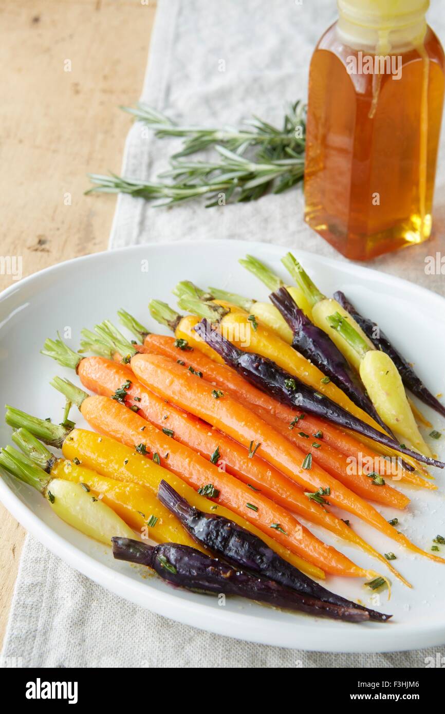 Still life de zanahorias baby asado con glaseado de miel y Romero Foto de stock