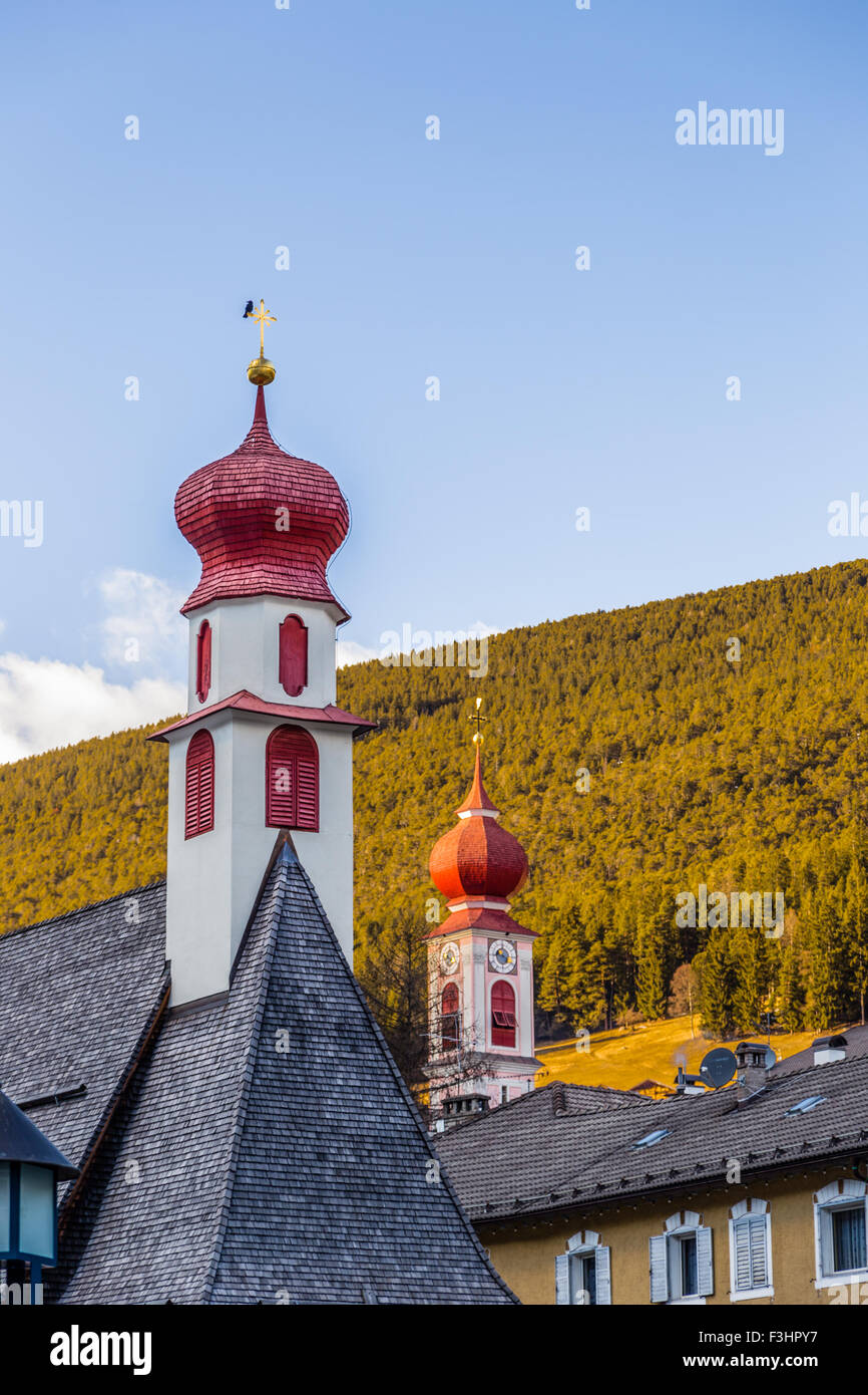 Rojo campanarios de la iglesia de un pueblo de montaña en Italia Foto de stock
