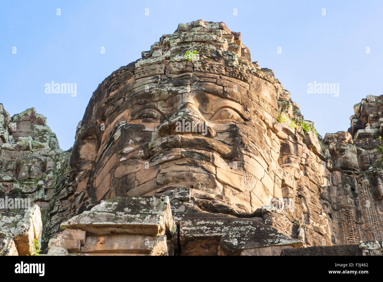 Uno de los rostros de piedra gigante en el templo Bayon en Angkor Wat, Camboya Foto de stock