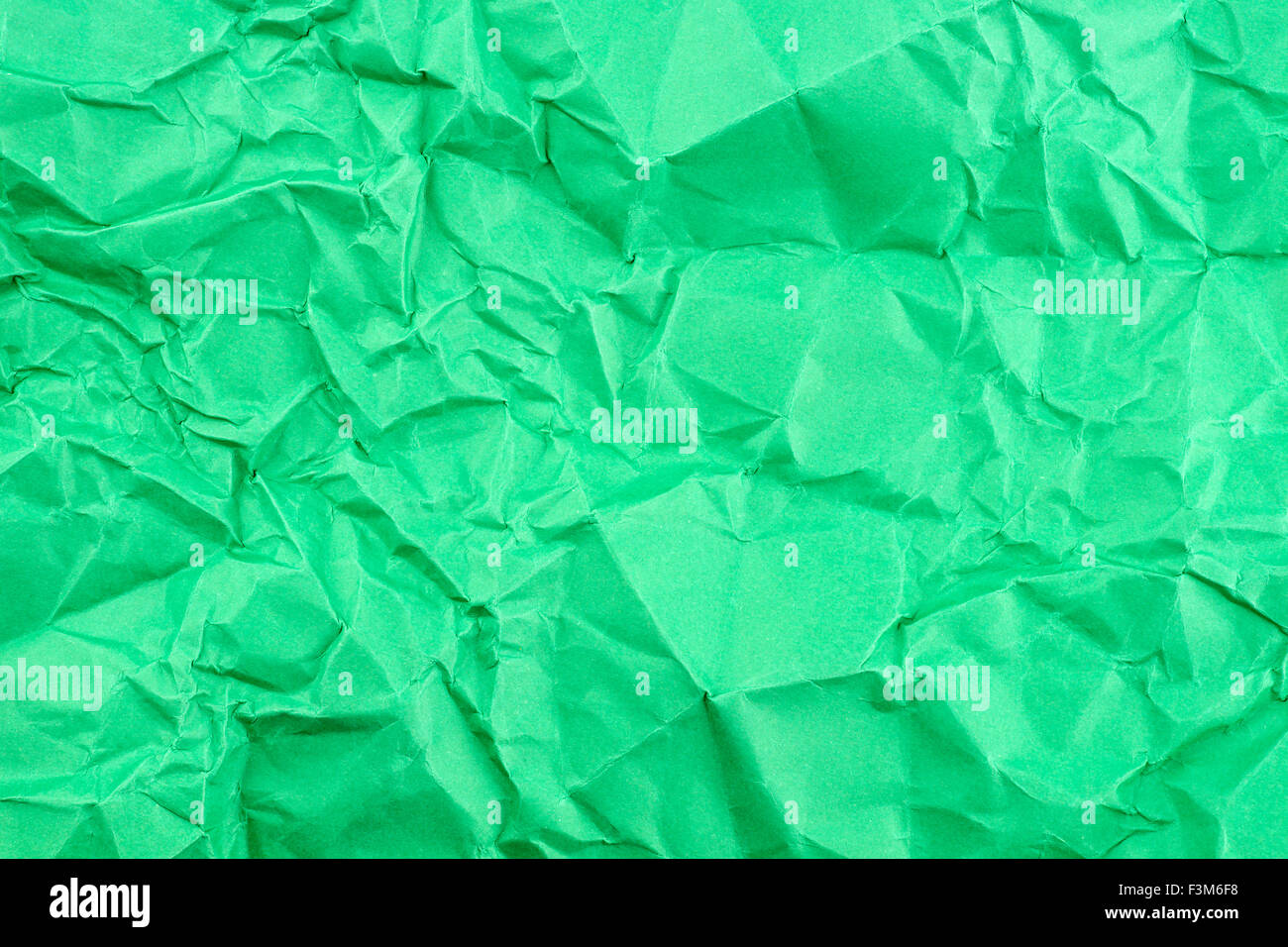 Textura de fondo verde brillante del papel doblado Foto de stock
