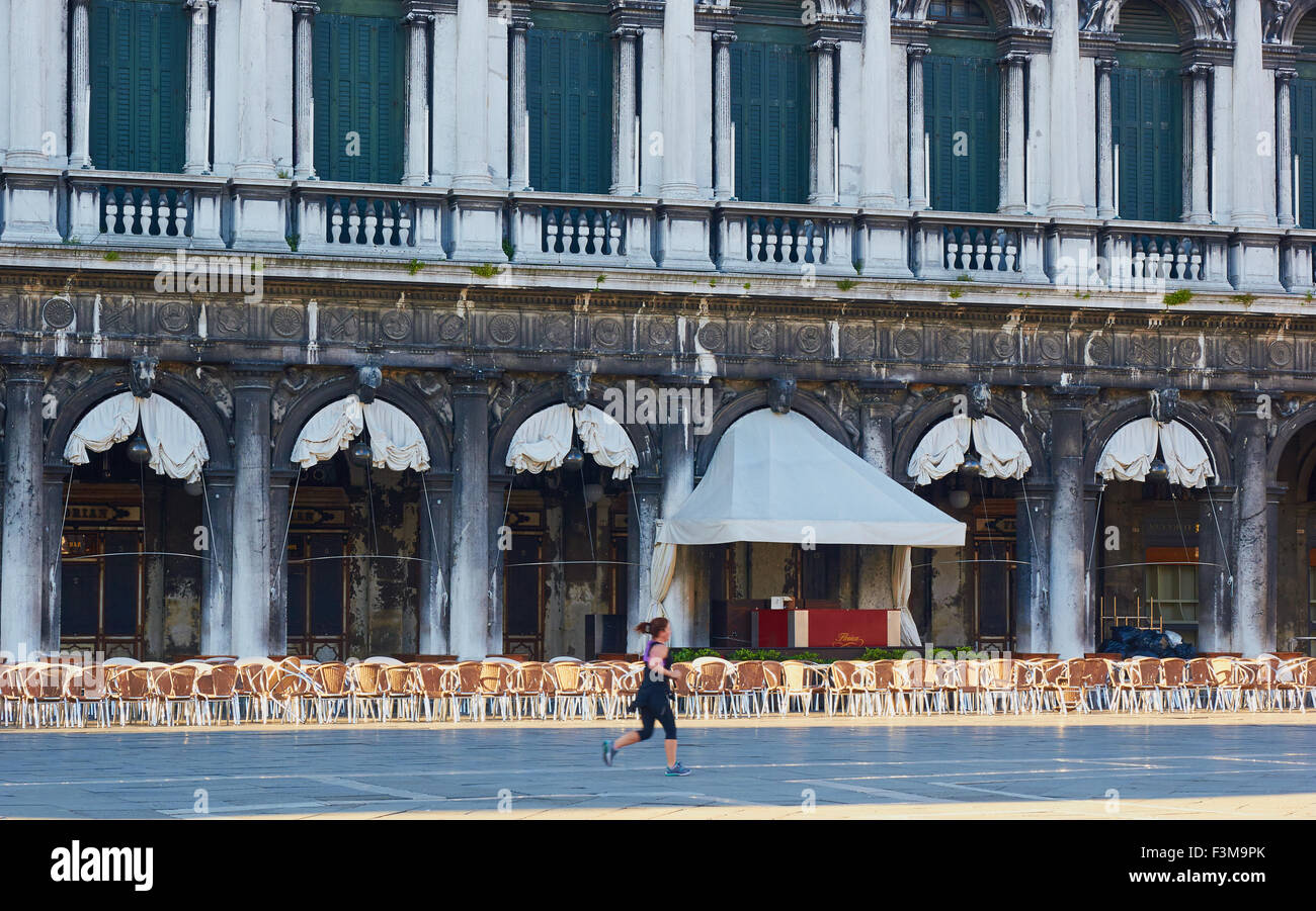 Mujer corriendo delante de Caffe Florian en un área vacía de la Piazza San Marco, Venecia Veneto Italia Europa Foto de stock