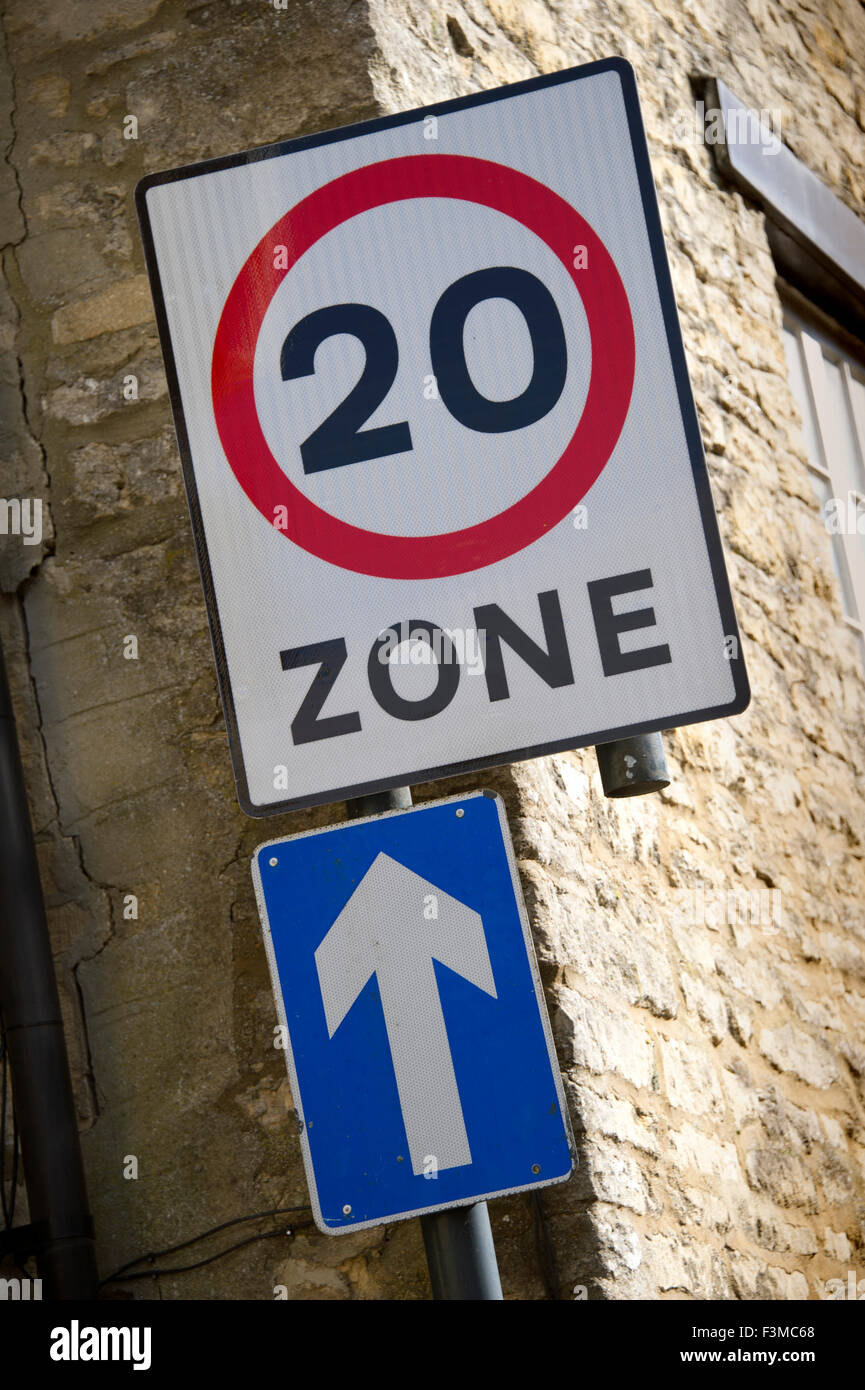 A 20 millas por hora (20 mph) Velocidad de zona y una señal de carretera del vehículo en una calle de Cirencester, Gloucestershire, Reino Unido restringen los coches. Foto de stock