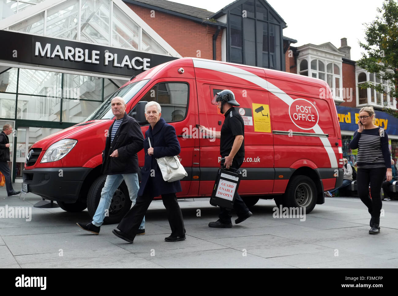 Un dinero en efectivo en tránsito blindado van & guardia; Red Post Office vehículo entrega a Primark en Southport, Merseyside, Reino Unido. Foto de stock