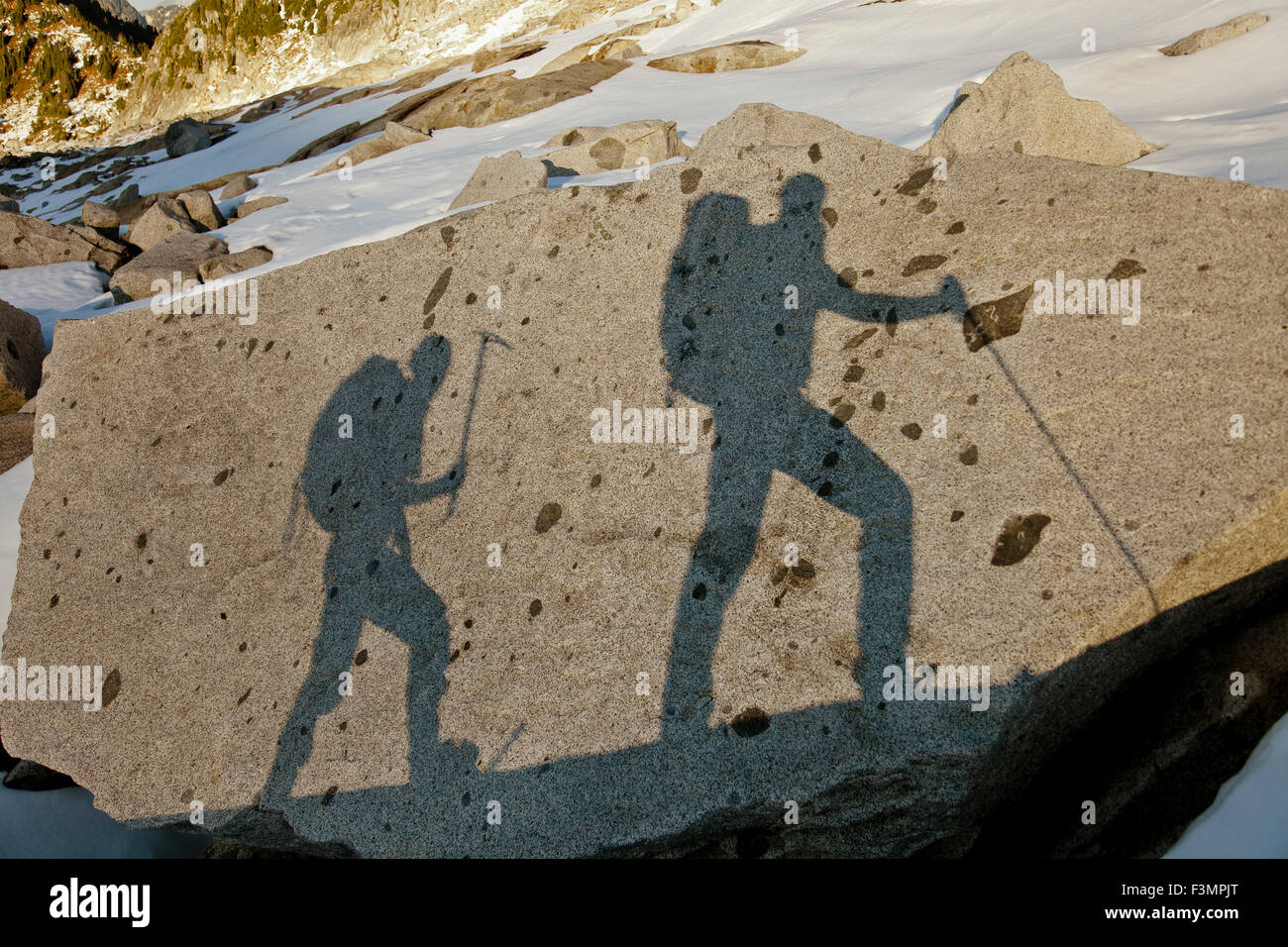 Las sombras de dos mochileros en una gran roca. Foto de stock