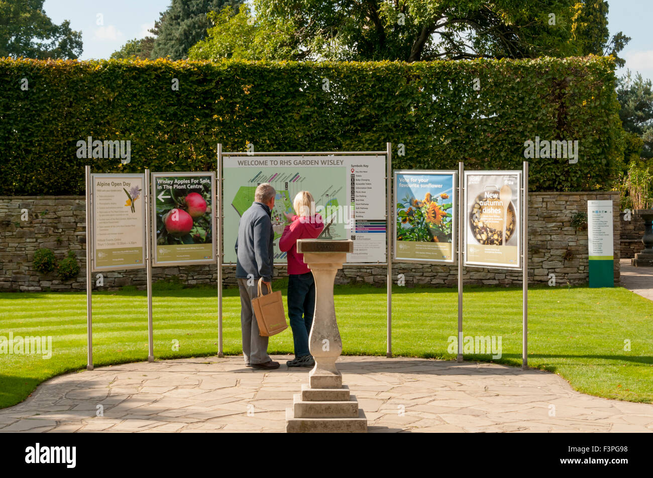 Los visitantes mira el mapa y el cartel de bienvenida en el Royal Horticultural Society Gardens, Wisley en Surrey. Foto de stock